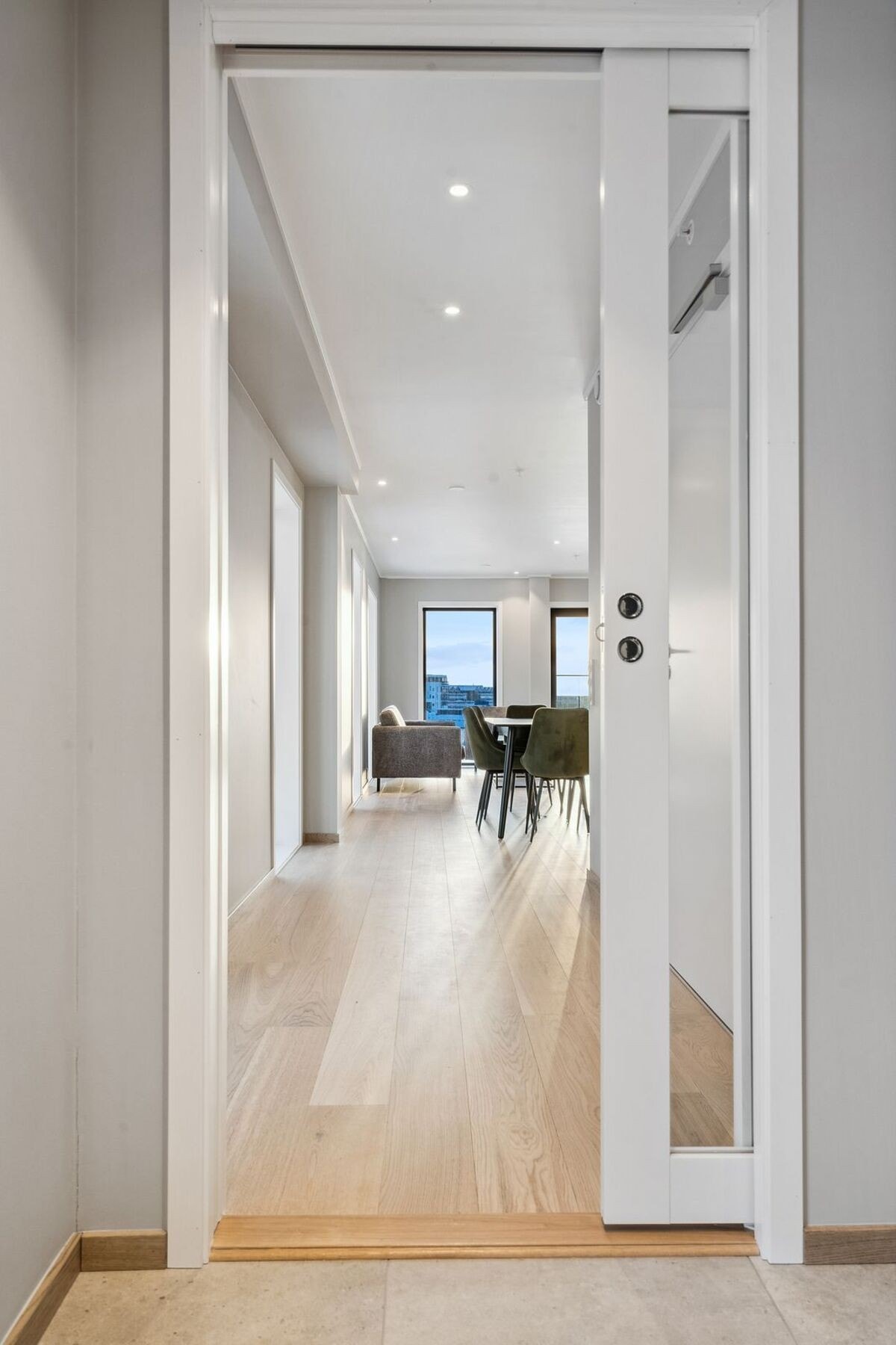 Fra gangen går du gjennom en skyvedør inn til resten av leiligheten med bad på høyre side og balkong på venstre. Galleribilde