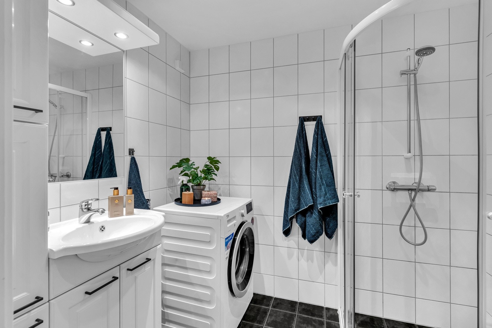 Med flislagt gulv og vegger, varme i gulvet og et praktisk opplegg for vaskemaskin har dette badet alt du trenger Galleribilde