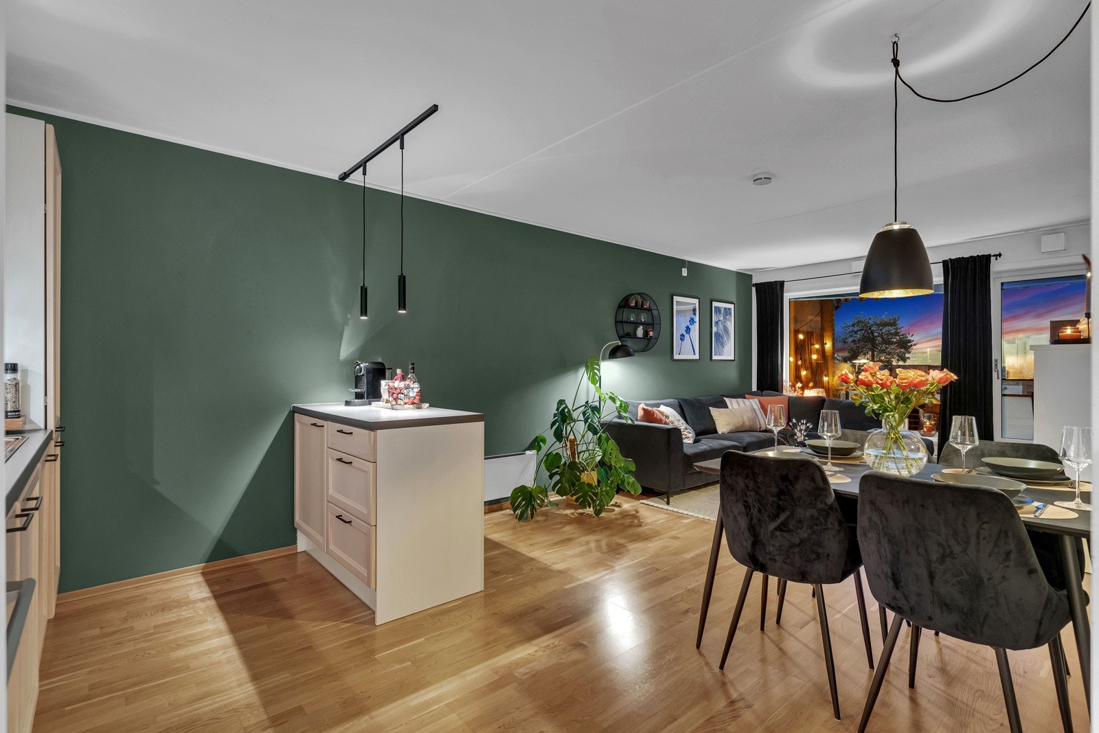 Den åpne planløsningen gir plass til både et stuebord og et spisebord, og parkettgulvet legger til en lun stemning Galleribilde