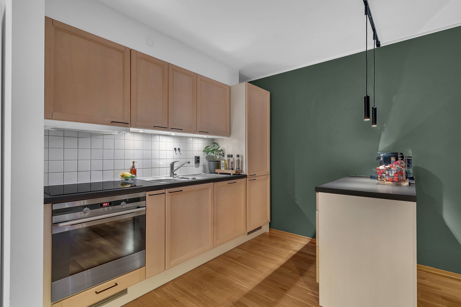 Dette kjøkkenet er enkelt, moderne og funksjonelt, med innredning som har enkle fronter og benkeplater av laminat Galleribilde