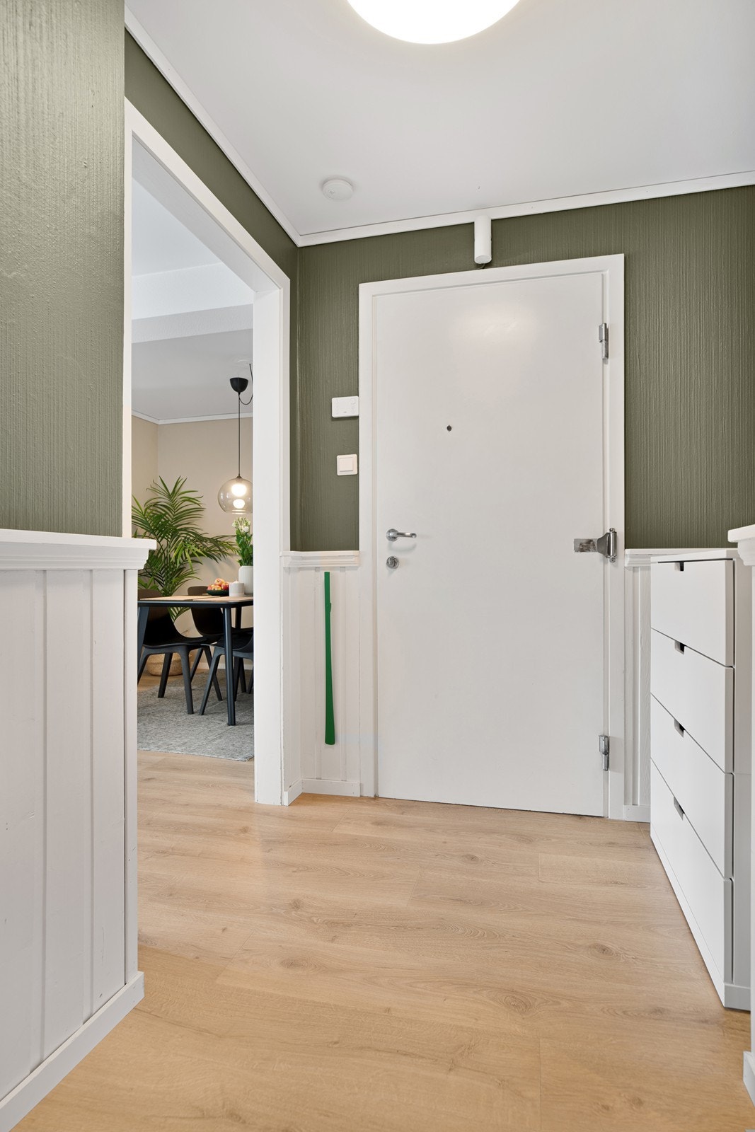 Entre med laminat på gulv og panel/tapet på vegg Galleribilde