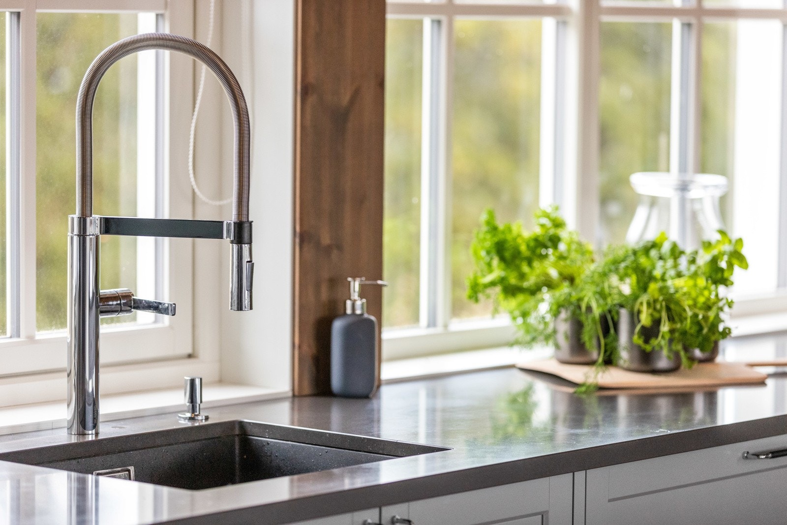 Kjøkken med benkeplate i stein og nedfelt kum med tidsriktig armatur. Galleribilde