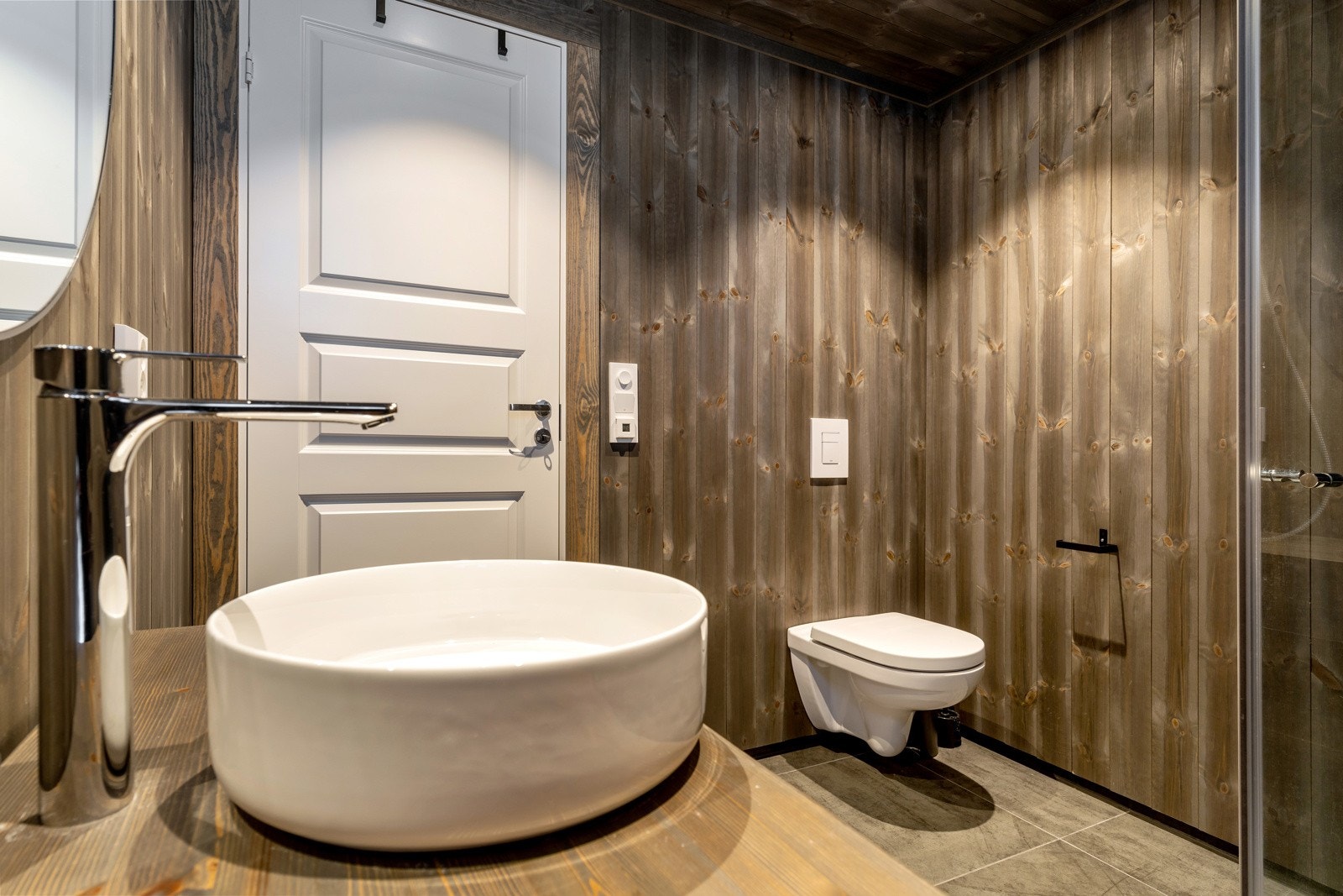 Gulvet er belagt med Cemento Grafite 60x60 fliser og mosaikk fliser i dusjen. Galleribilde