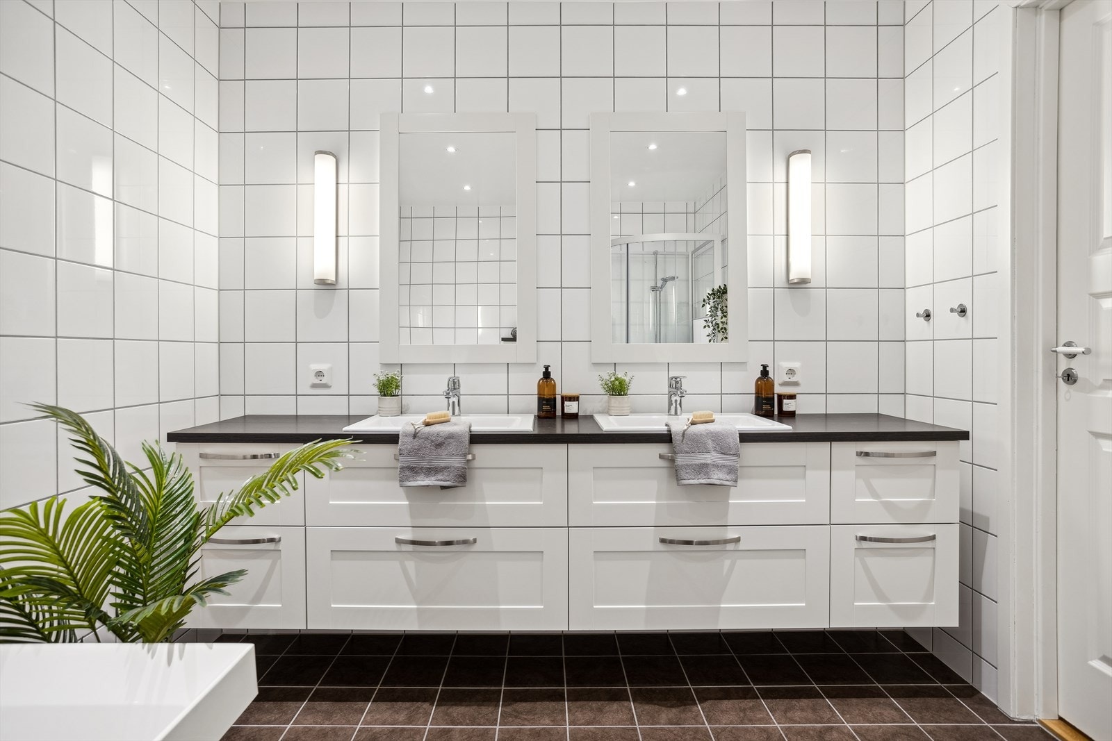 I denne etasjen finner vi et stilrent og romslig bad med keramiske fliser, elektriske varmekabler og moderne innredning, inkludert dusjkabinett, badekar, vegghengt spyletoalett og dobbel servant Galleribilde