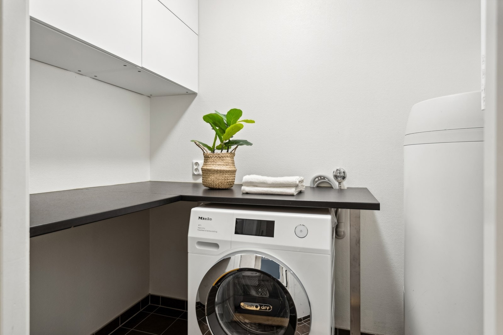 Vaskerom i underetasjen med 200L varmtvannsbereder, vaskemaskinoppkobling og sentral for rør i rør-system Galleribilde