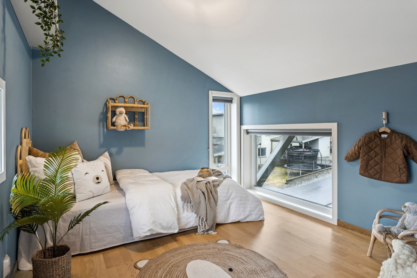 Sjarmerende soverom med lysblå vegger, parkettgulv og vinduer som sørger for godt med naturlig lysinnslipp Galleribilde