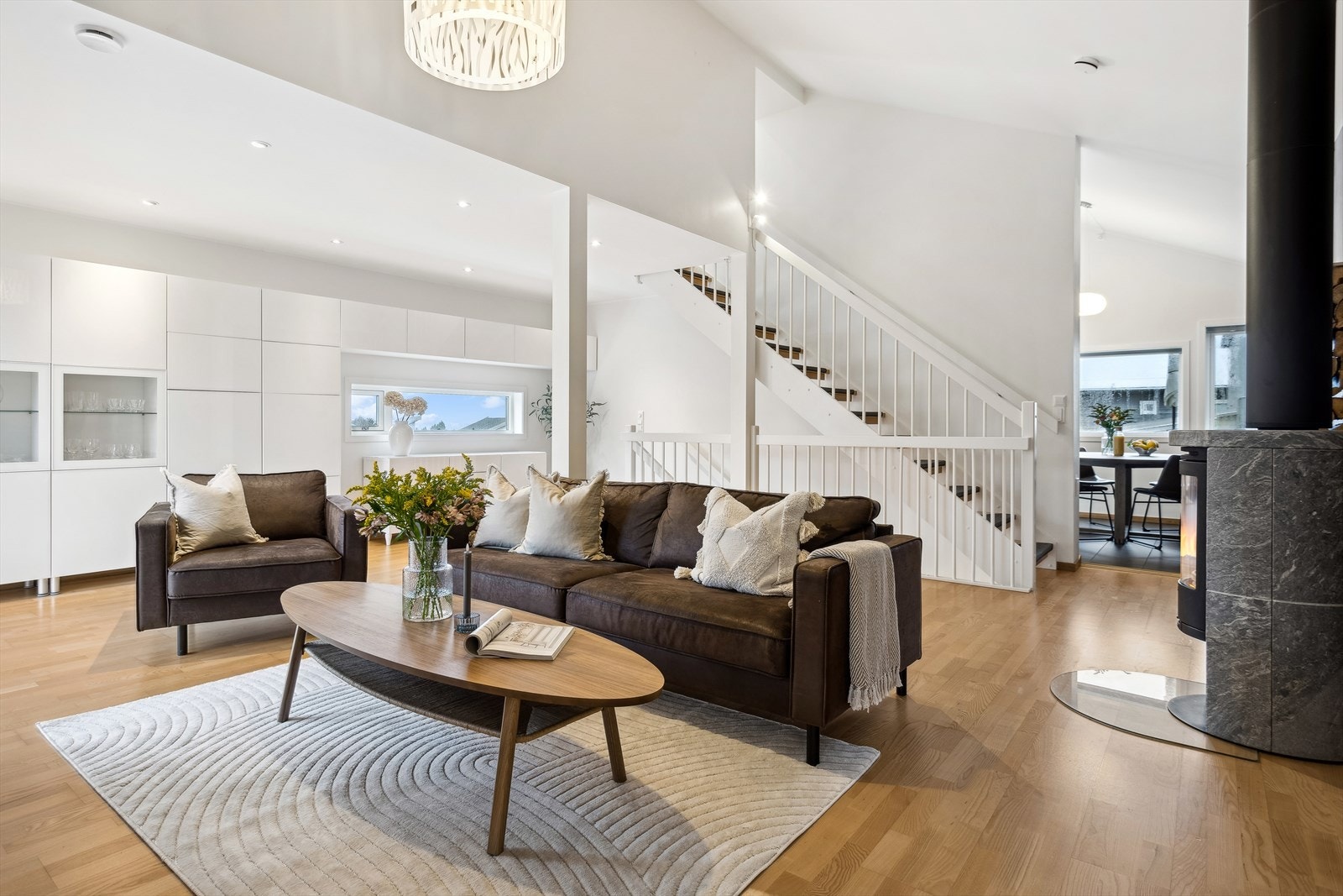 Romslig stue med imponerende takhøyde og koselig peisovn, ideell for avslapning og hyggelige sammenkomster med familie og venner. Galleribilde