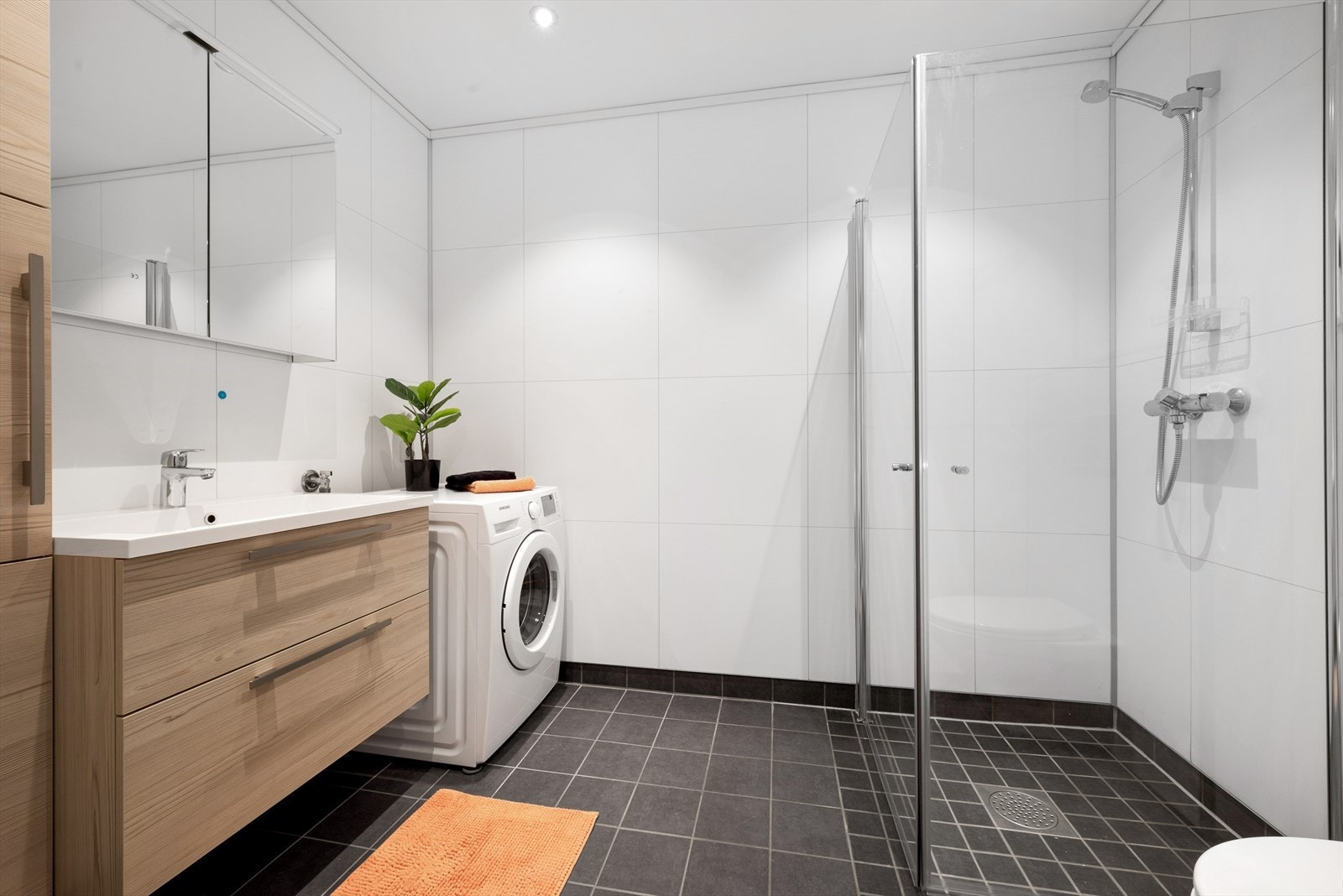 Flislagt bad med gulvvarme og opplegg for vaskemaskin. Galleribilde