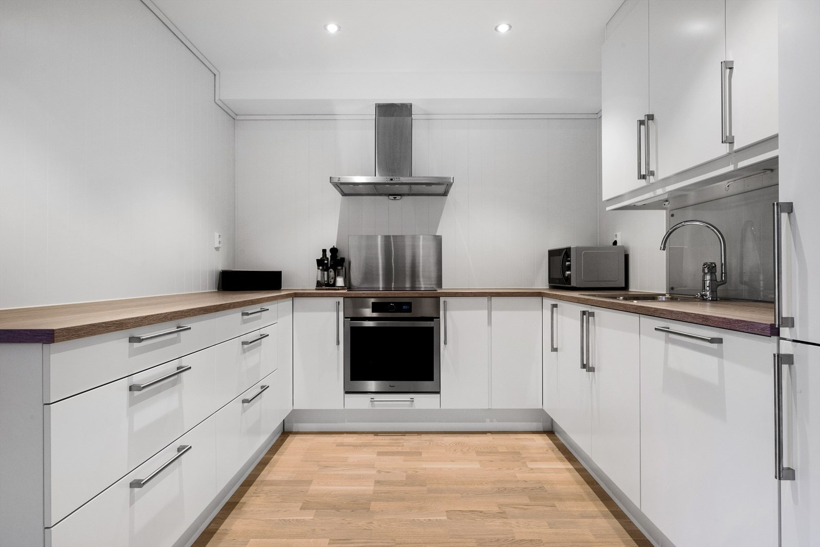 Romslig kjøkkeninnredning med integrerte hvitevarer. Galleribilde