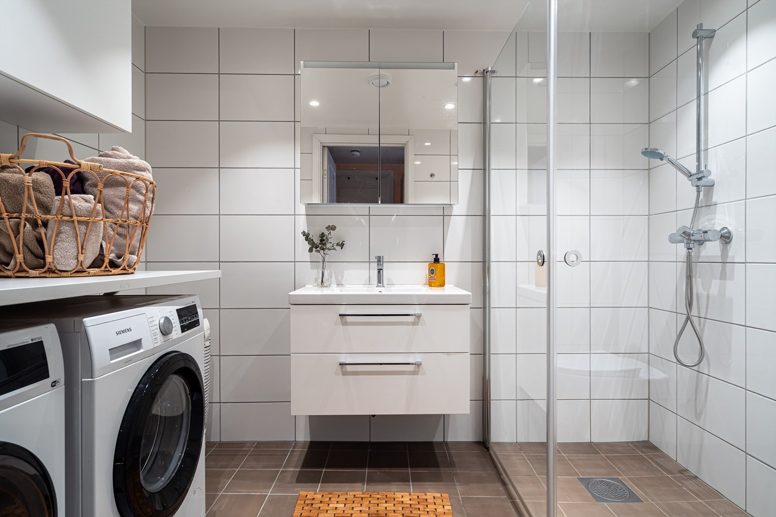 Lyst og romslig baderom med dusjnisje og moderne sanitærutstyr. Galleribilde