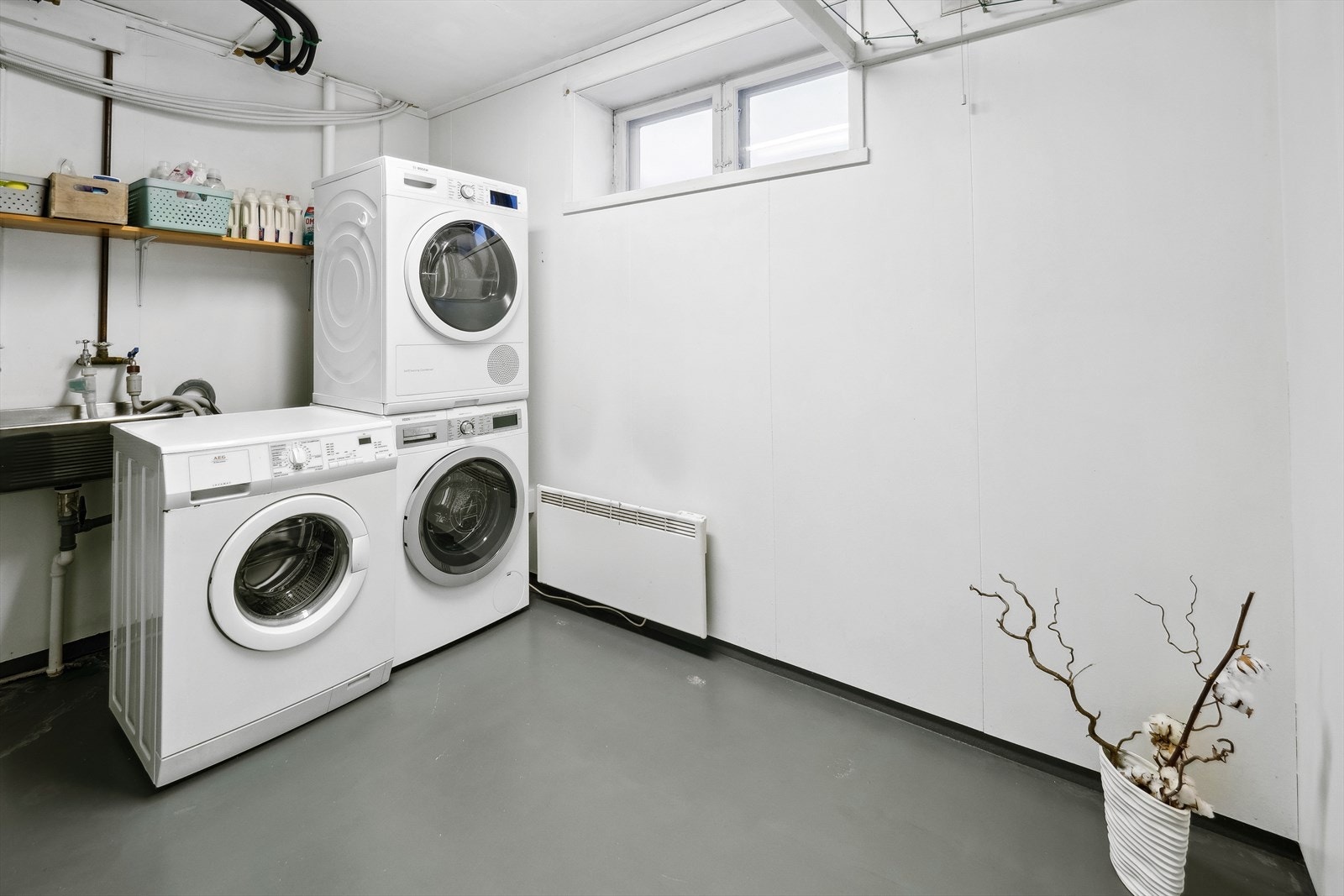 Vaskerom innredet med utslagsvask og opplegg for vaskemaskin. Galleribilde