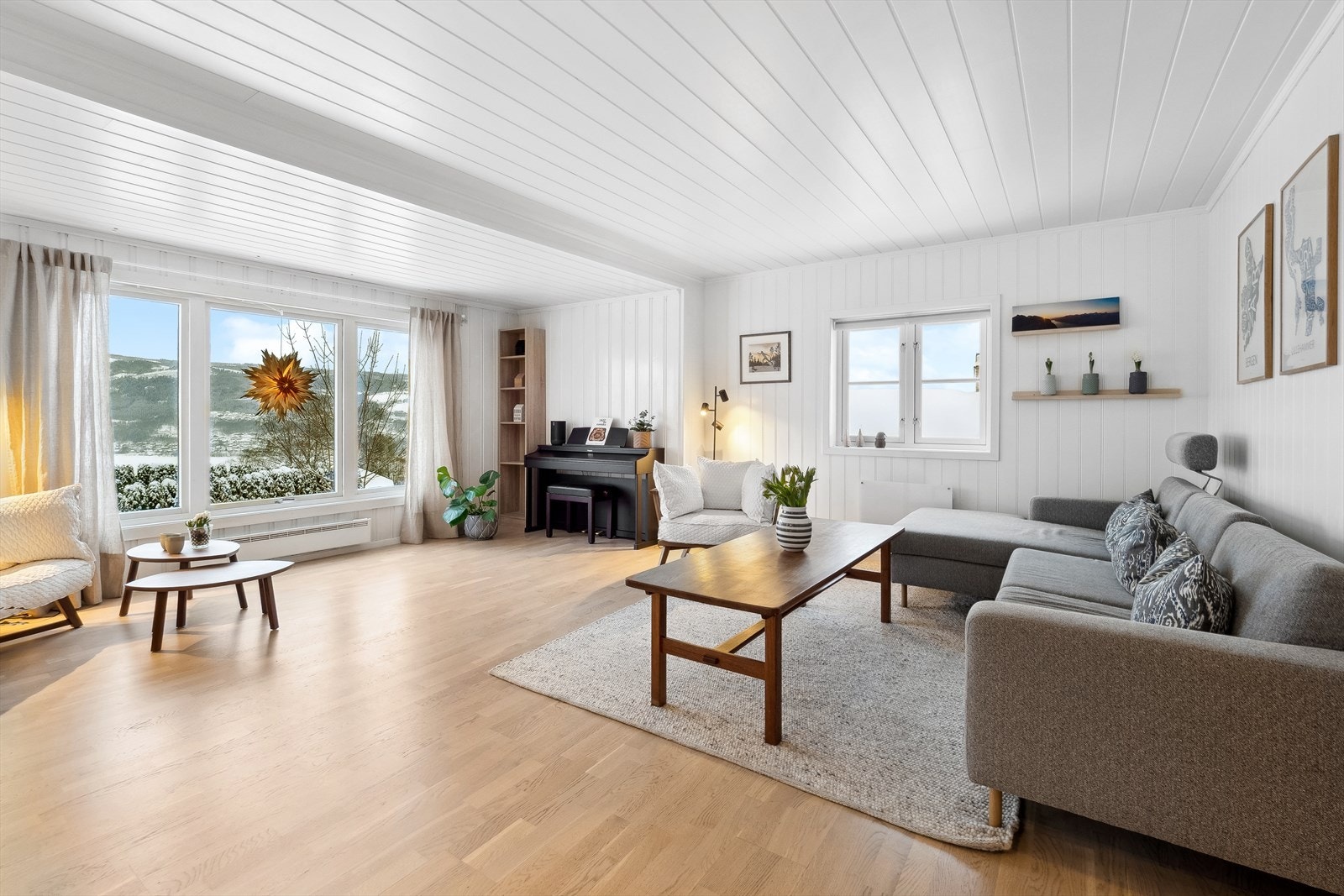 Stue med eikeparkett og lysmalt panel. Galleribilde