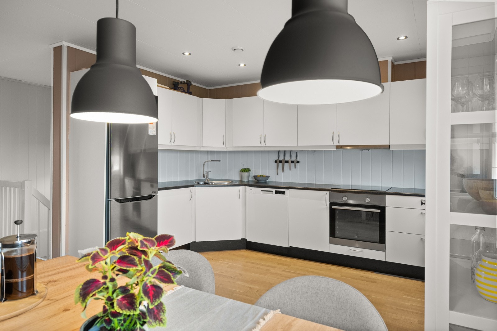 Stilren kjøkkeninnredning fra 2015 med slette fronter og benkeplate av laminat med nedsenket oppvaskkum. Galleribilde