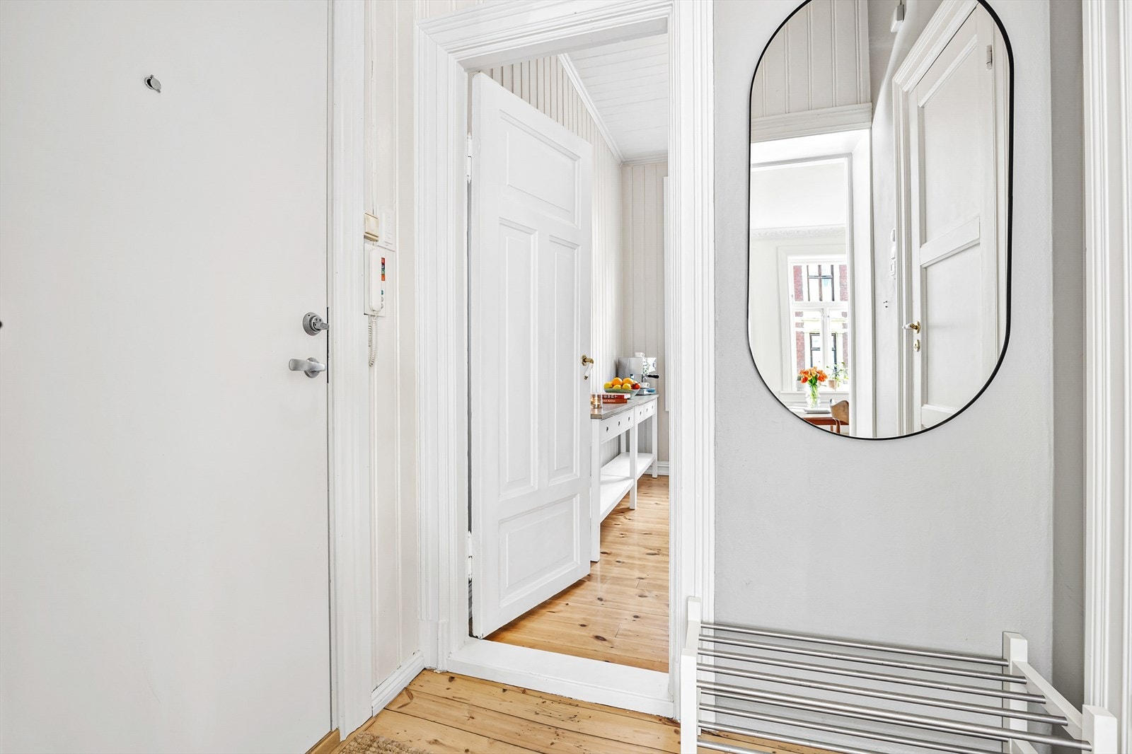 Innbydende entré med dørcalling, god plass til å henge fra seg yttertøy og sko på hver side. Inngang til kjøkken, bad og stue. Galleribilde