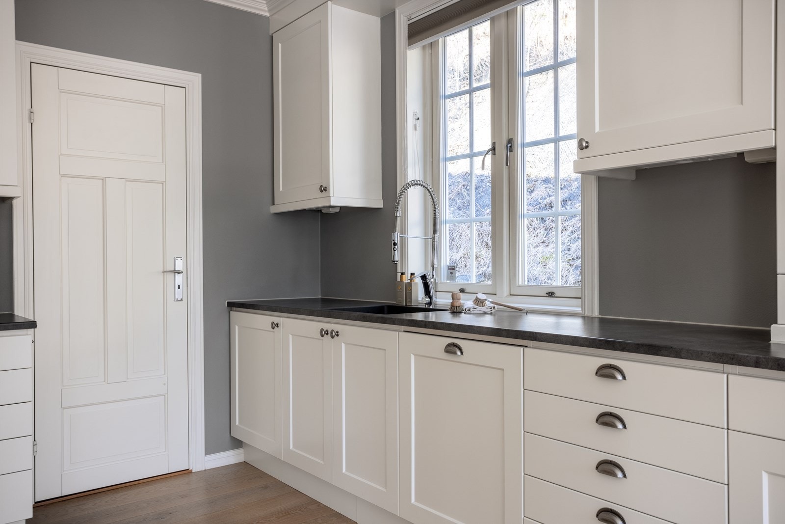 Detaljer som flislagt sprutsone, takhøye overskap og downlightsbelysning. Galleribilde