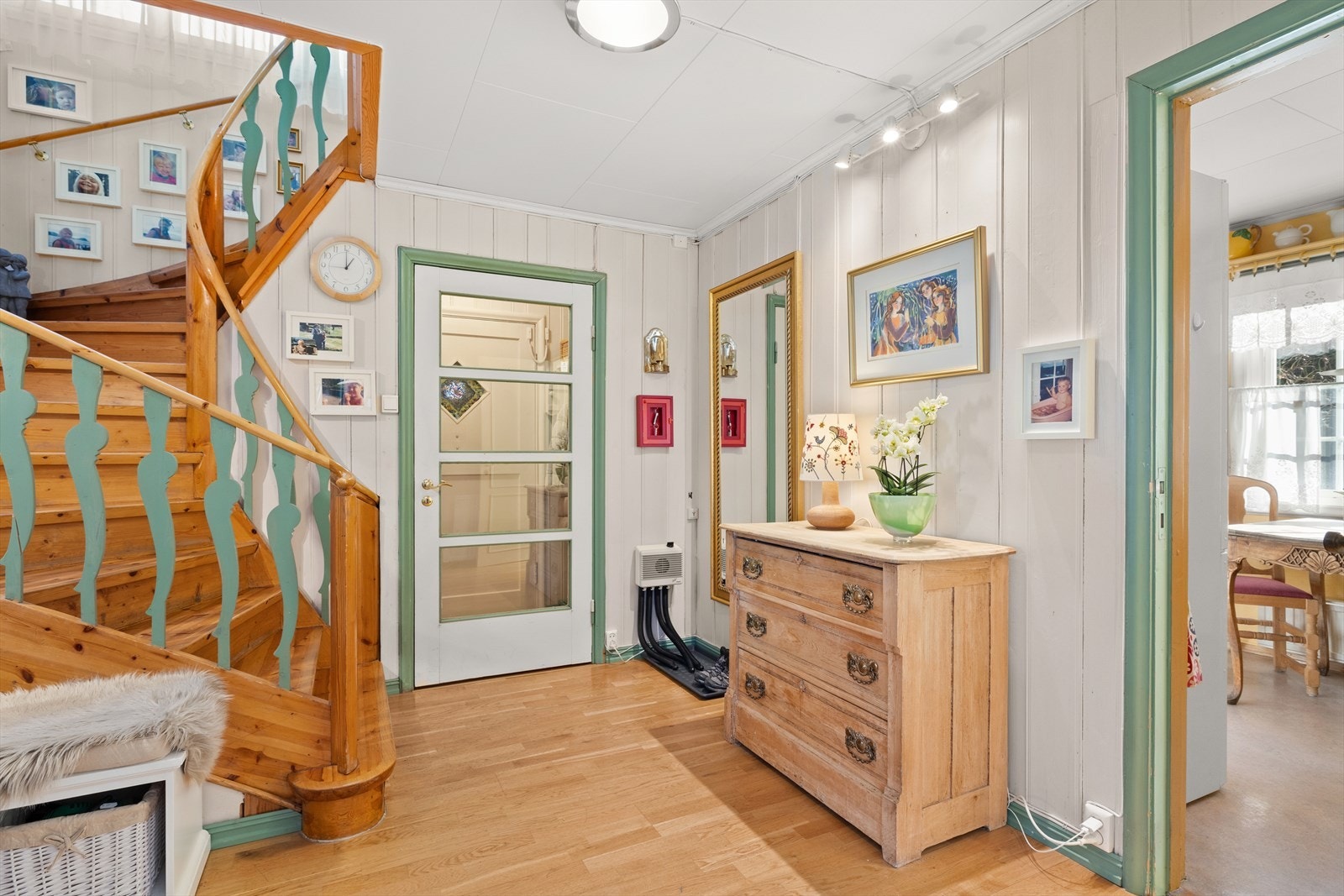 Stor entré/hall med støpejernsovn som har dør til kjøkken, stue og soverom samt trapp opp til 2. etasje Galleribilde