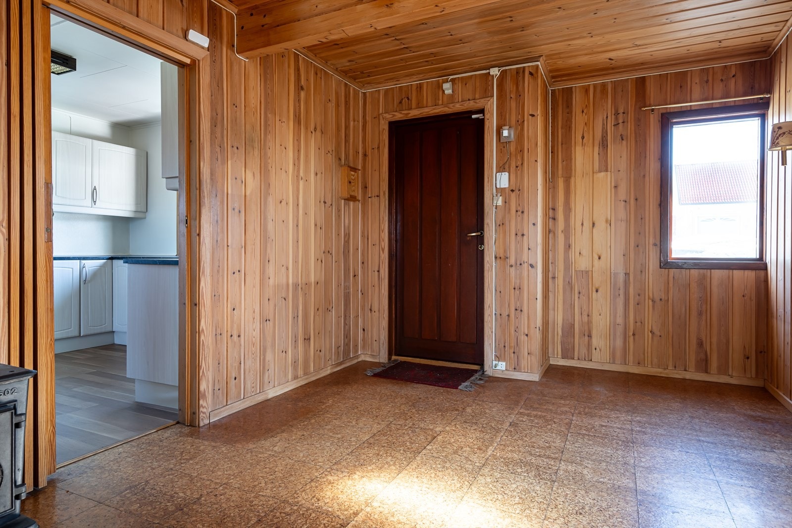 Entreen er romslig og får dagslys fra et vindu. Veggene er kledd med panel og på gulvet er det korkfliser. Galleribilde