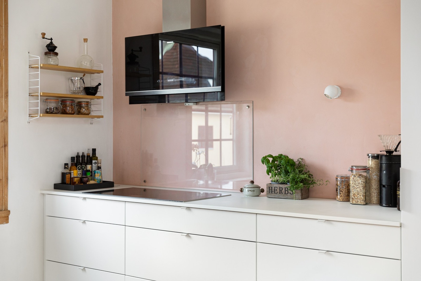 Innredningen har hvite glatte fronter og laminert benkeplate. Ekstra dyp benkeplass (XL). Praktisk med glassplate i benkeryggen ved platetoppen og oppvaskkummen. Galleribilde