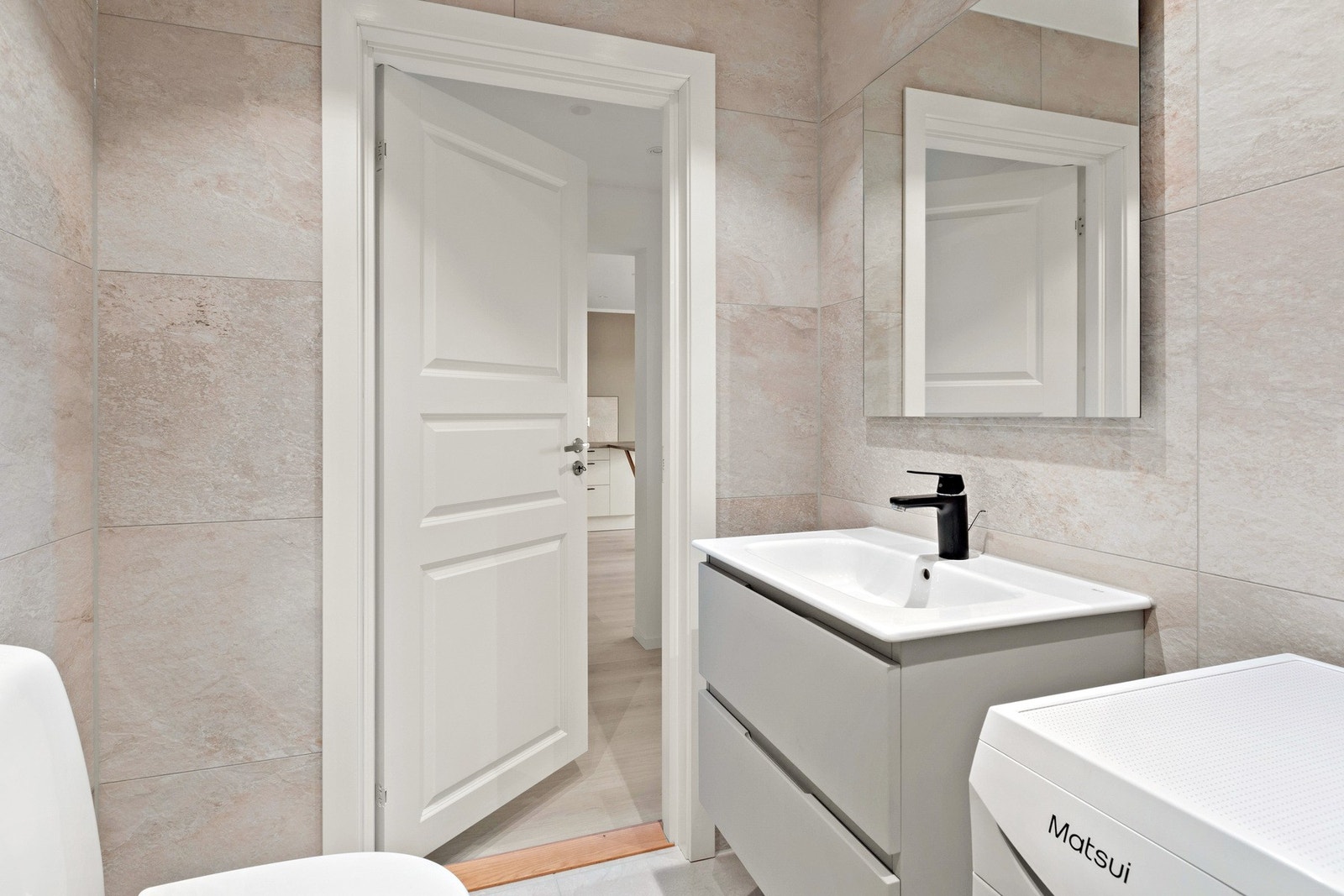 På badet har du moderne baderomsinnredning, opplegg for vaskemaskin, dusjhjørne og toalett. Det er også felles vaskeri for borettslaget i kjeller. Galleribilde