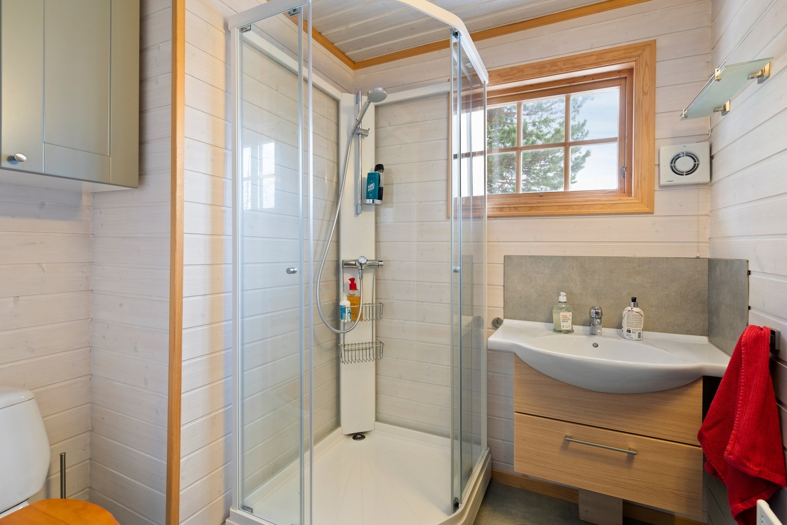 Badet har gulvoverflate av laminat, og er utstyrt med diverse skap, baderomsinnredning, wc, avtrekksvifte og dusjkabinett Galleribilde