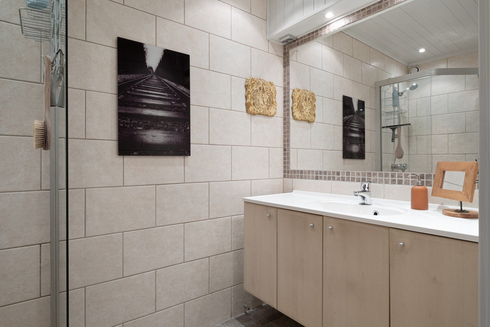 Badet er utstyrt med dusjhjørne, mekanisk avtrekk og servant i skap. Galleribilde