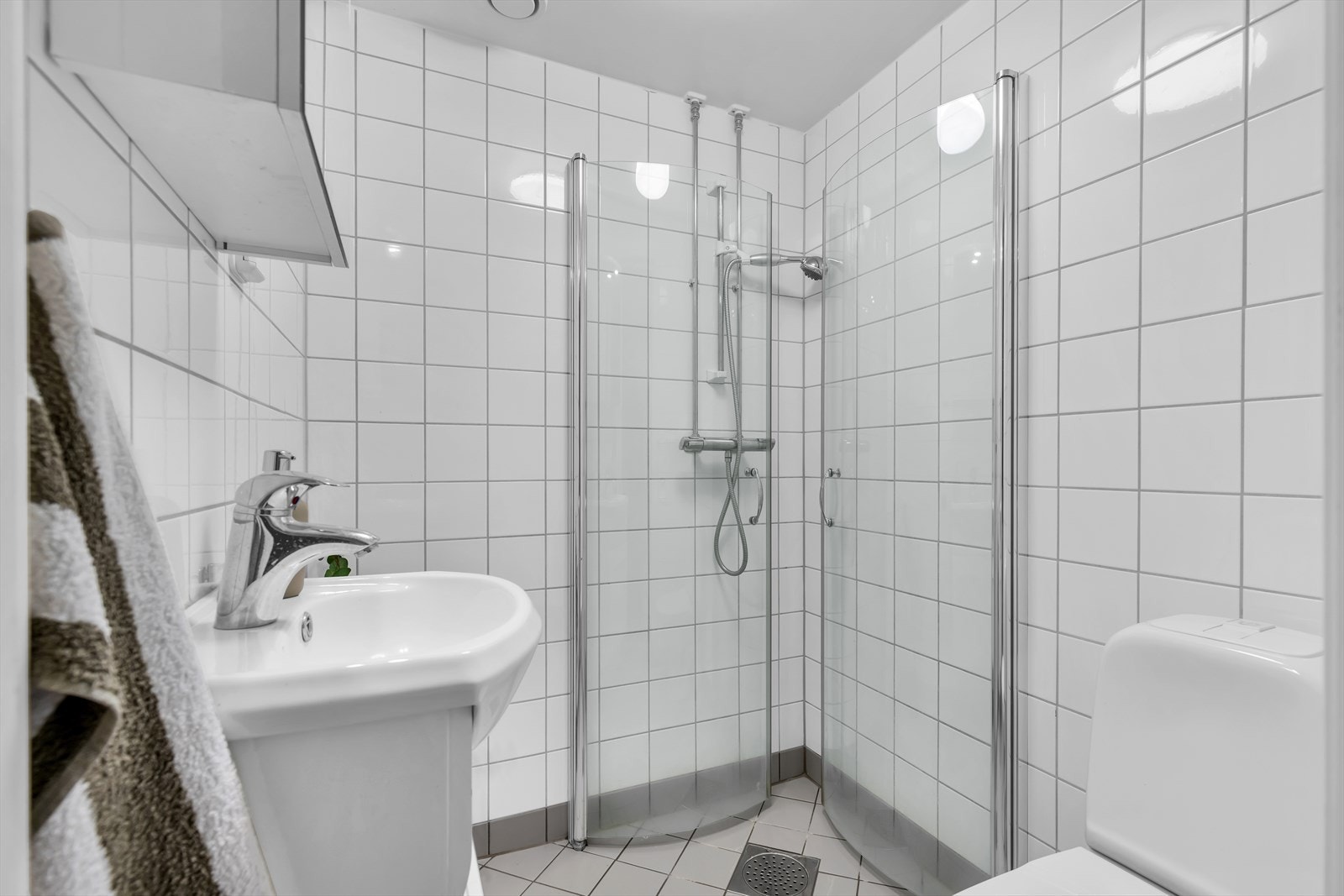 Pent flislagt bad med varme i gulv. Downlights i himling og opplegg for vaskemaskin Galleribilde