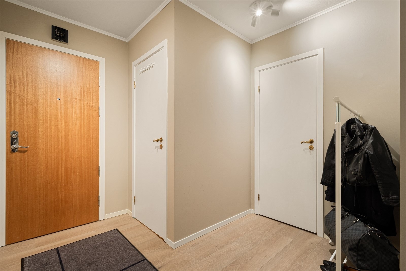 Velkommen inn! Vi møtes av en lys og innbydende entre. Her får vi et umiddelbart inntrykk av boligens moderne standard. Det er plass til garderobeskap, skohylle eller knagger til å henge opp yttertøy. Galleribilde