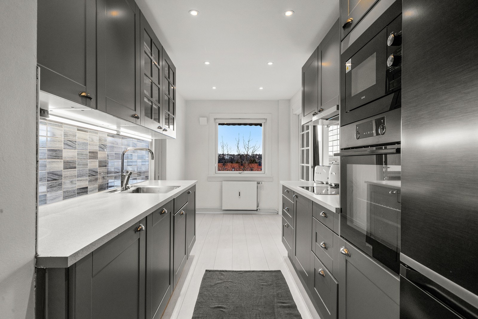 Innredningen ble montert i 2019 og er fra Norema. Kjøkkenet har mørke profilerte fronter og laminerte benkeplater. Galleribilde