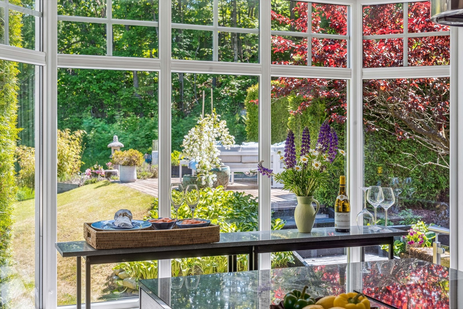 Kjøkken har en åpen løsning med store vindusflater som vender ut mot hagen og grøntarealer. Galleribilde