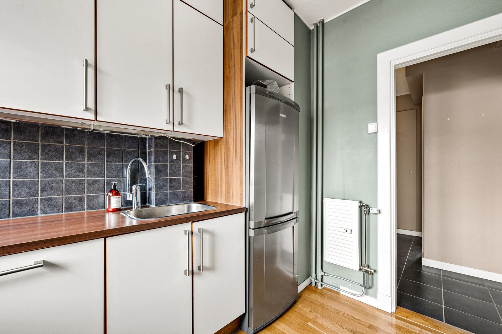 Kjøkkenet har ventilator med kullfilter, benkeplate av laminat, fliser på vegg, samt stikkontakt og belysning over kjøkkenbenk. Galleribilde