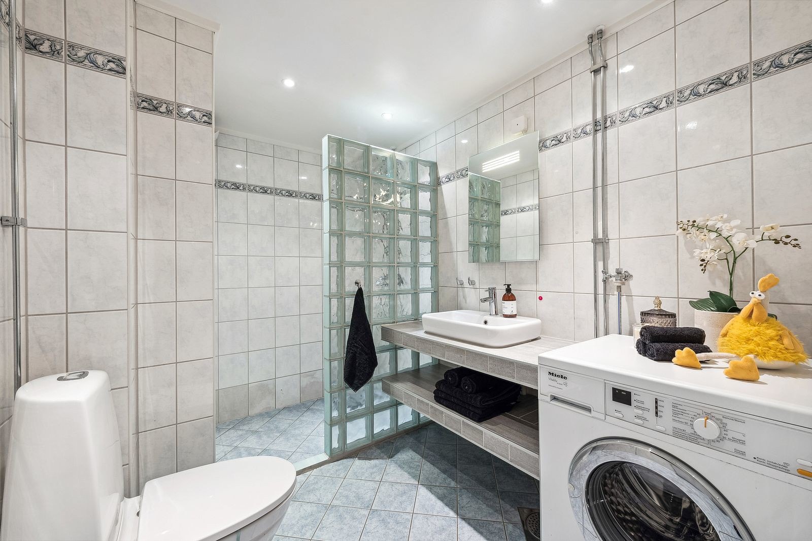 Badet består av flislagte overflater med varmekabler på gulv. Galleribilde