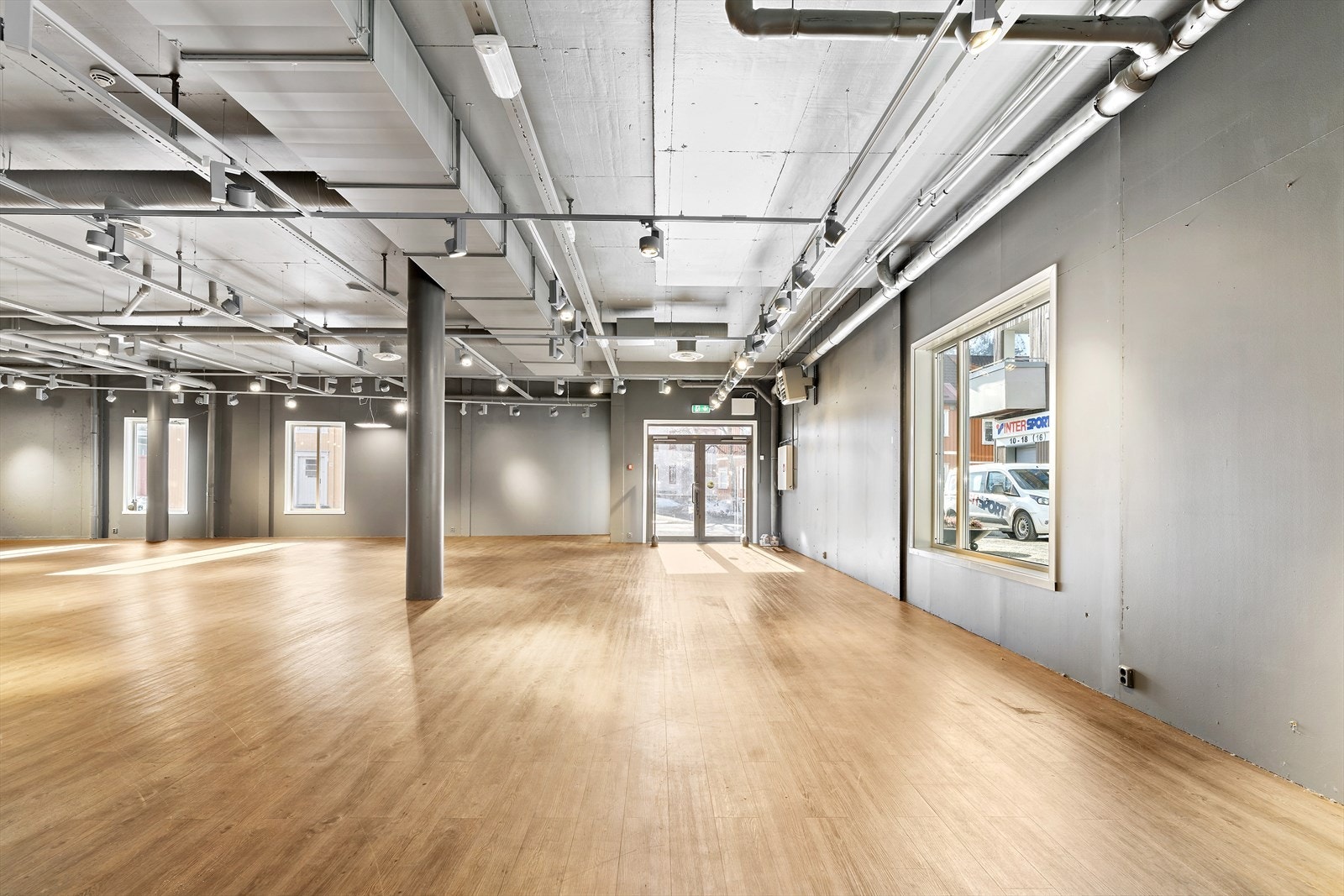 Mot inngangsdør - du ser parkeringsplass og Sjøsiden senter i vinduet på siden Galleribilde