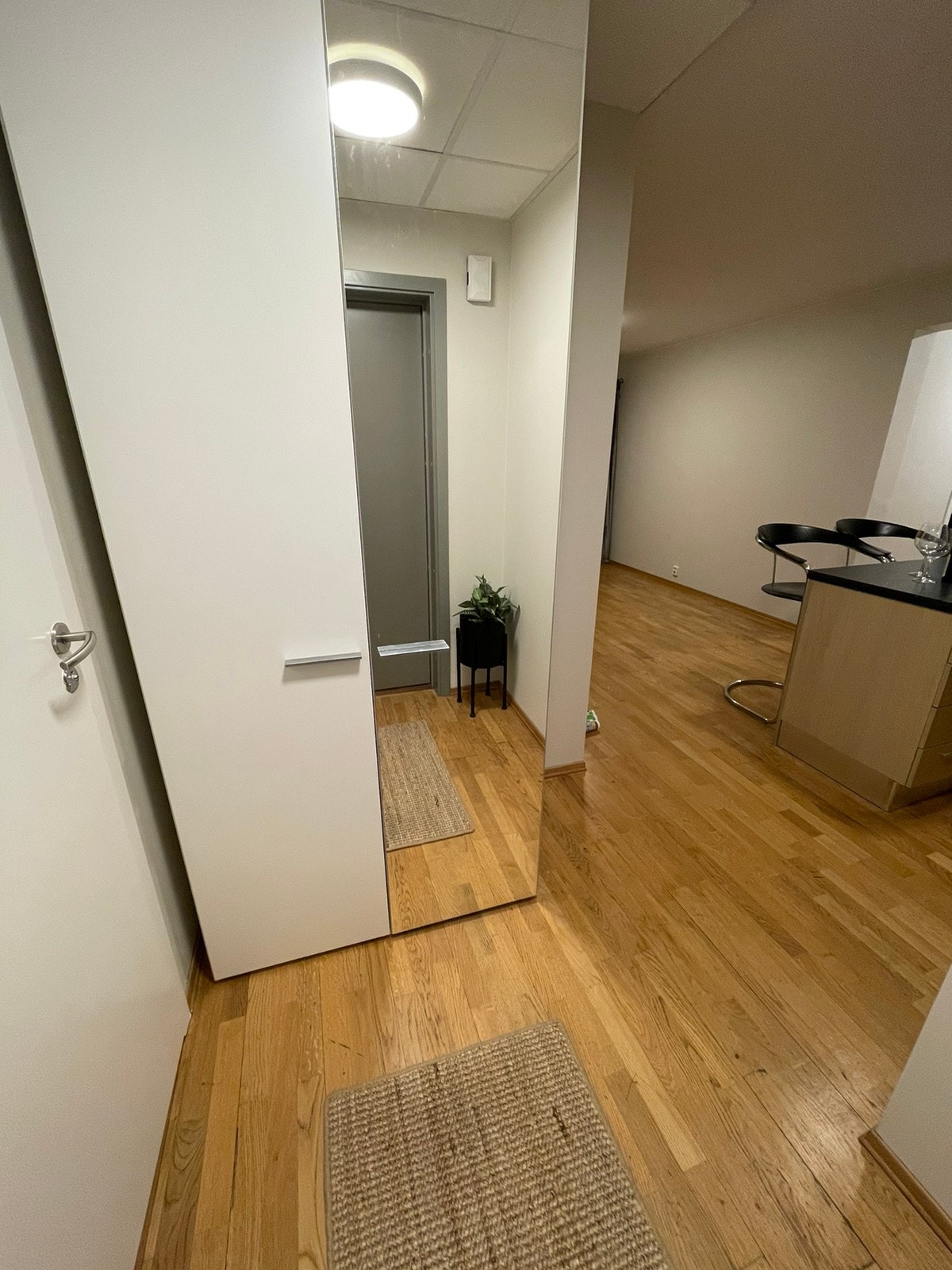 Garderobeskap med speil i enden av gangen, kjøkken til høyre. Galleribilde