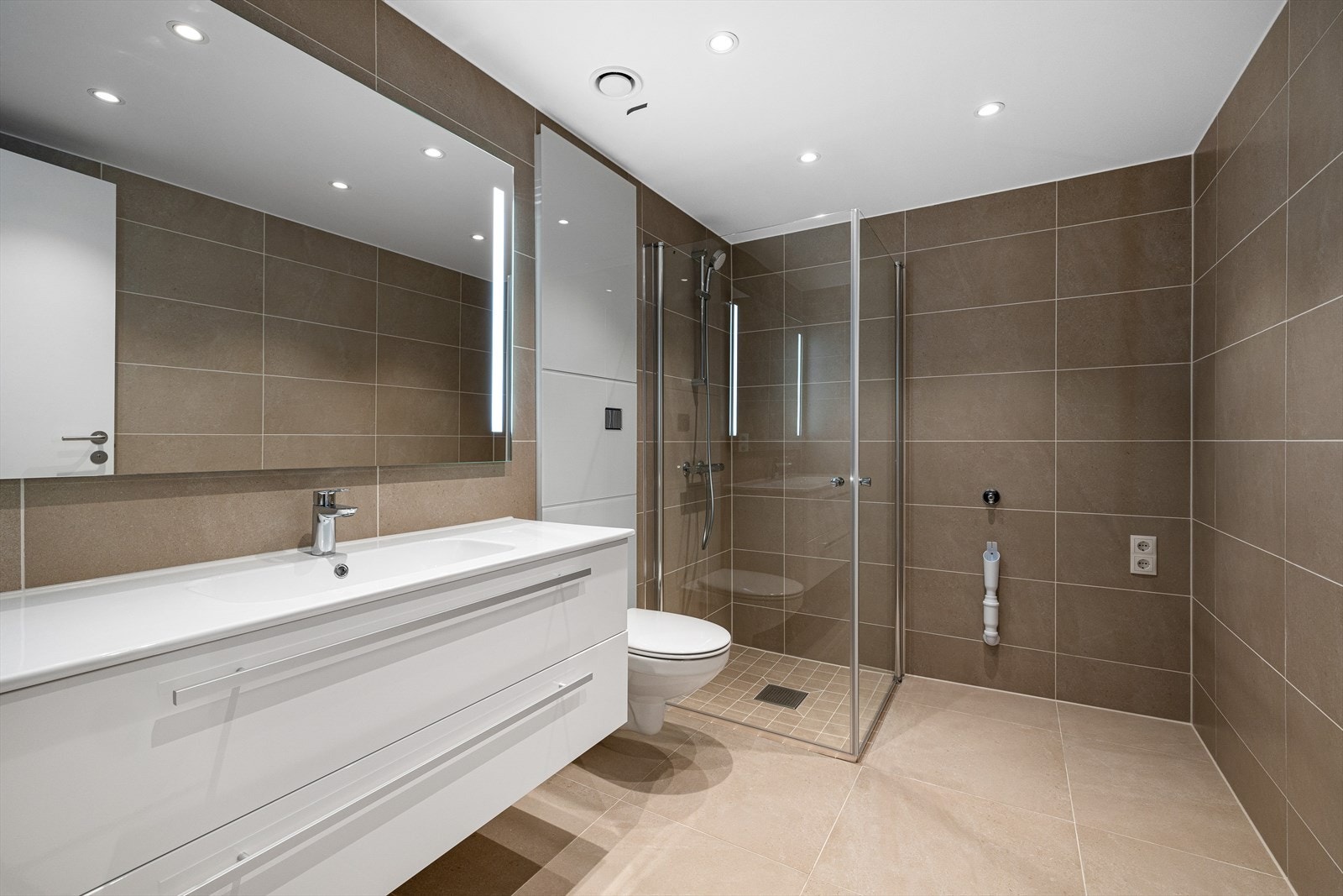 Eksklusivt bad med vannbåren gulvvarme 60*60 fliser på gulv. Grohe vegghengt toalett samt Grohe blandebatterier. 120 innredning med nedfelt servant. Downlights i tak. Galleribilde