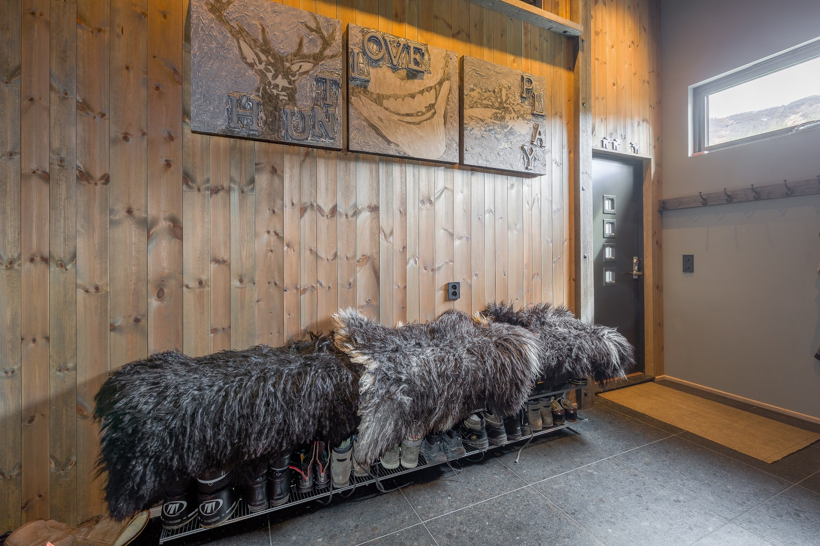Stor yttergang med plass til ski, oppvarming til støvler og mange knagger for ytterklær Galleribilde