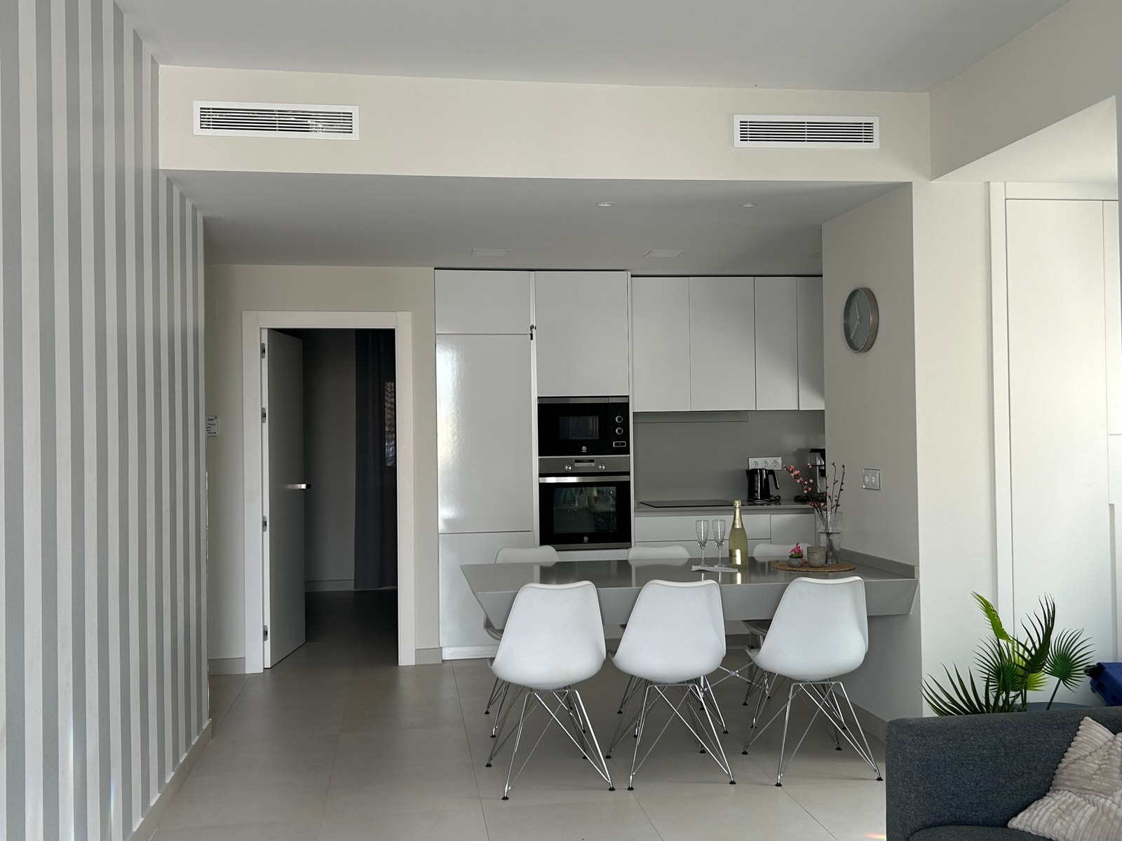 Kjøkken og dør inn til ene soverommet. Det er aircondition i hele leiligheten, og her ser en ventilasjonsristene opp under taket. Galleribilde