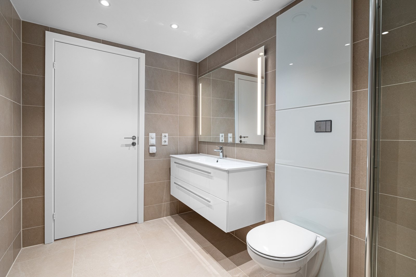 Eksklusivt bad med vannbåren gulvvarme 60*60 fliser på gulv. Grohe vegghengt toalett samt Grohe blandebatterier. 120 innredning med nedfelt servant. Downlights i tak. Galleribilde