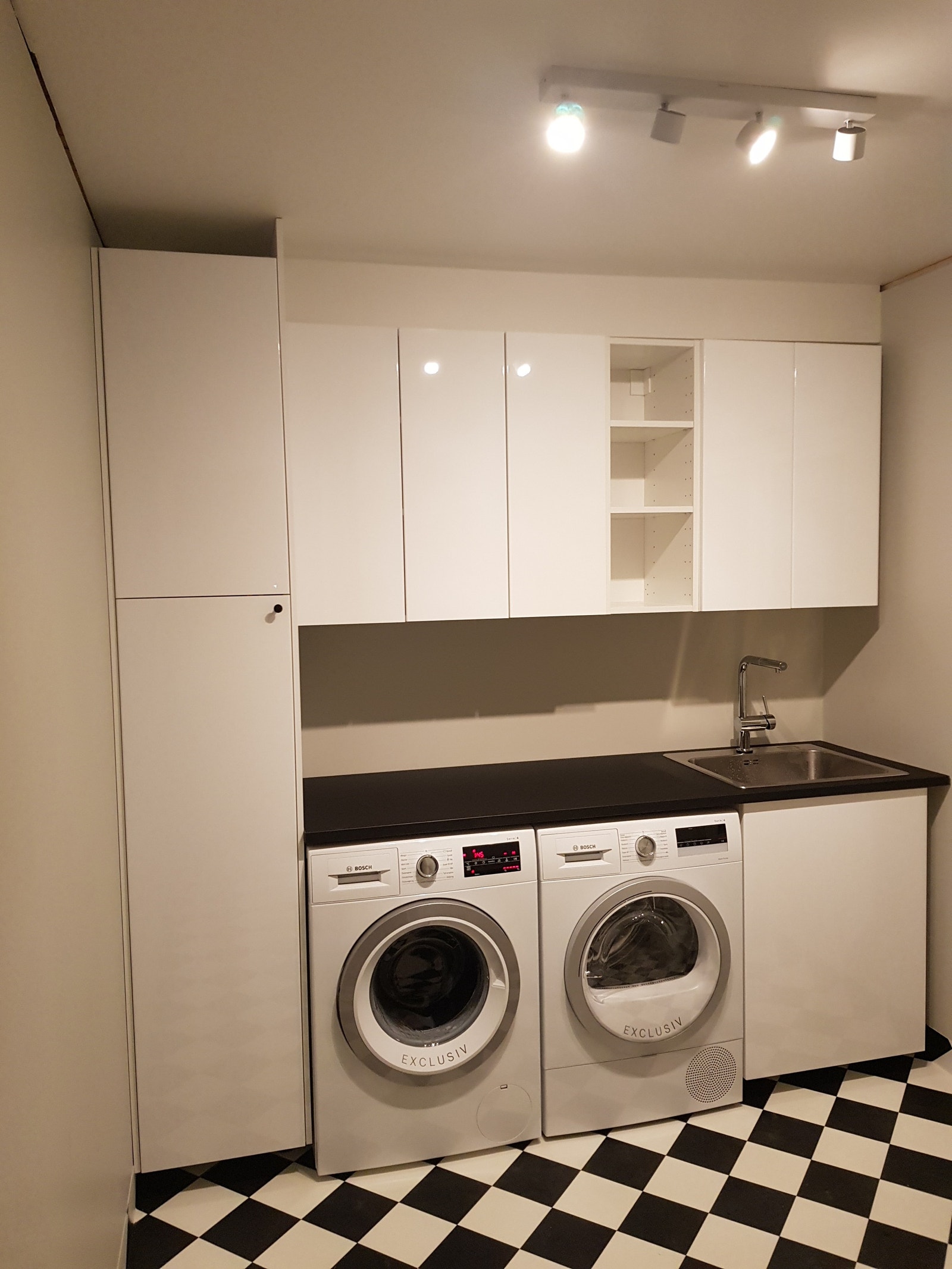 Vaskerommet med vaskemaskin og tørketrommel, vask, benkeplass og mye oppbevaringsplass. Galleribilde