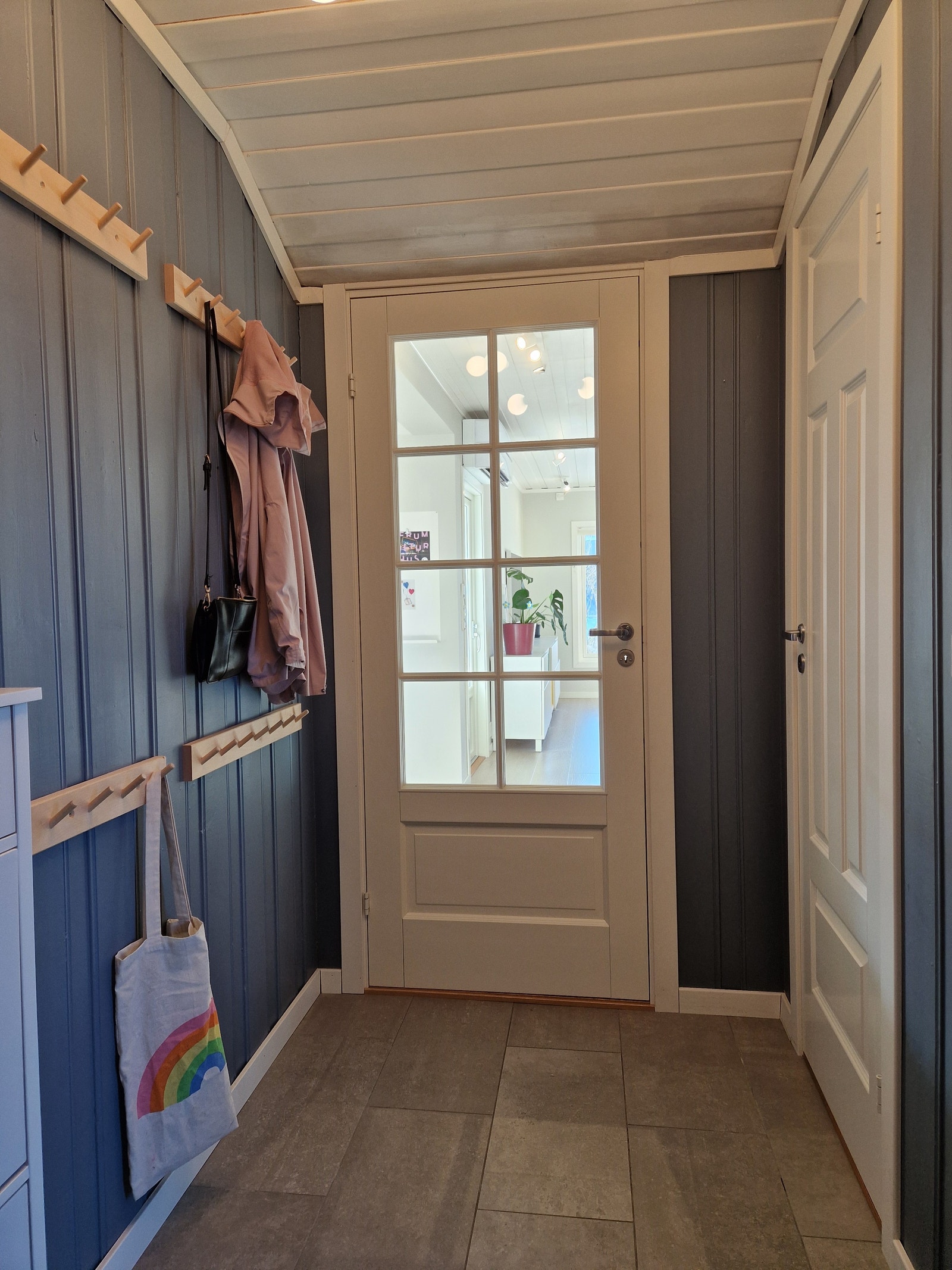 Mange knagger for å henge opp jakker m.m. i entreen. Dør til toalett ses til høyre i bildet. Hyggelig glassdør inn mot kjøkken og stue. Galleribilde