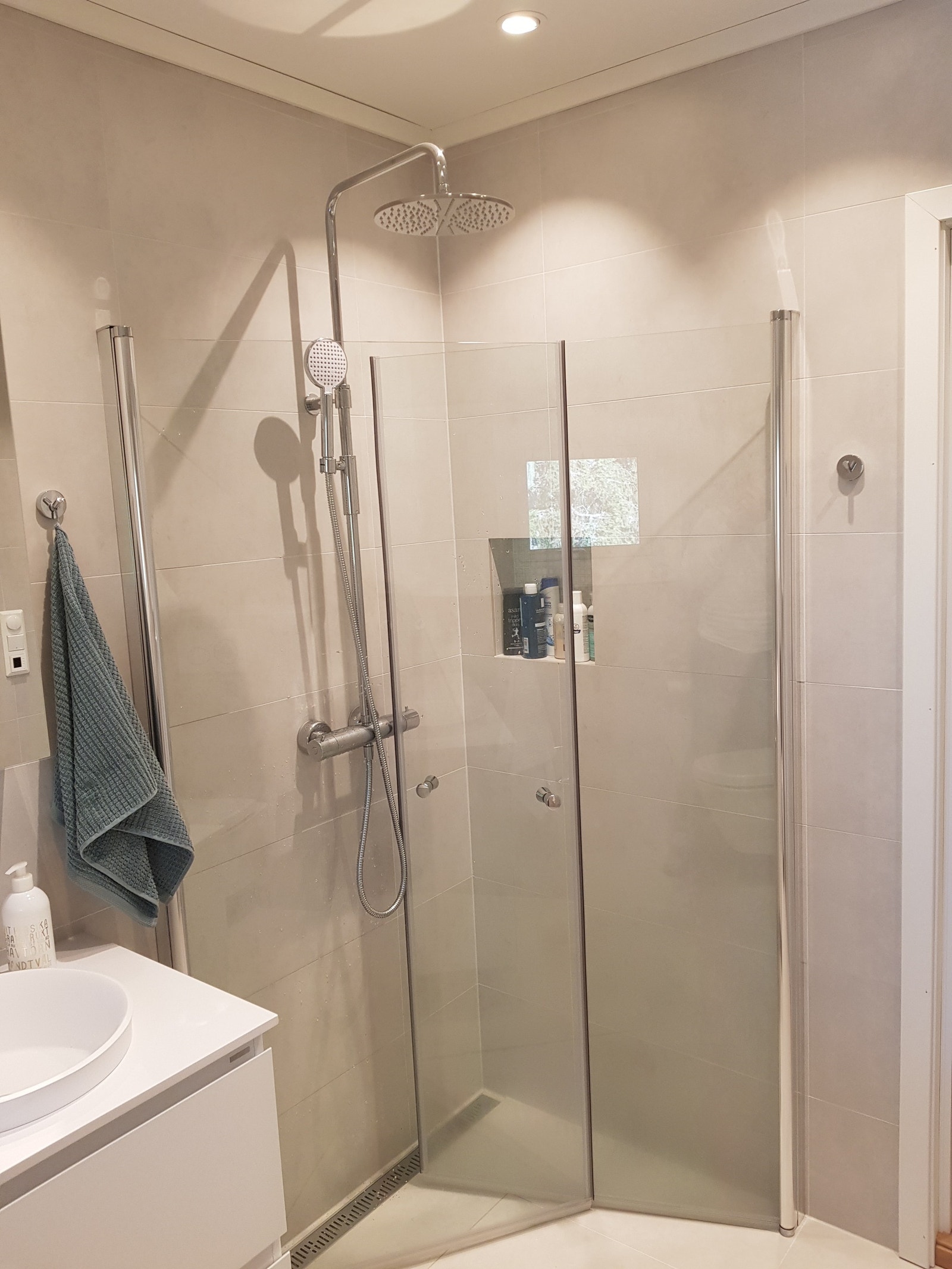 Regndusj og dusjhylle for oppbevaring av dusjartikler. Galleribilde