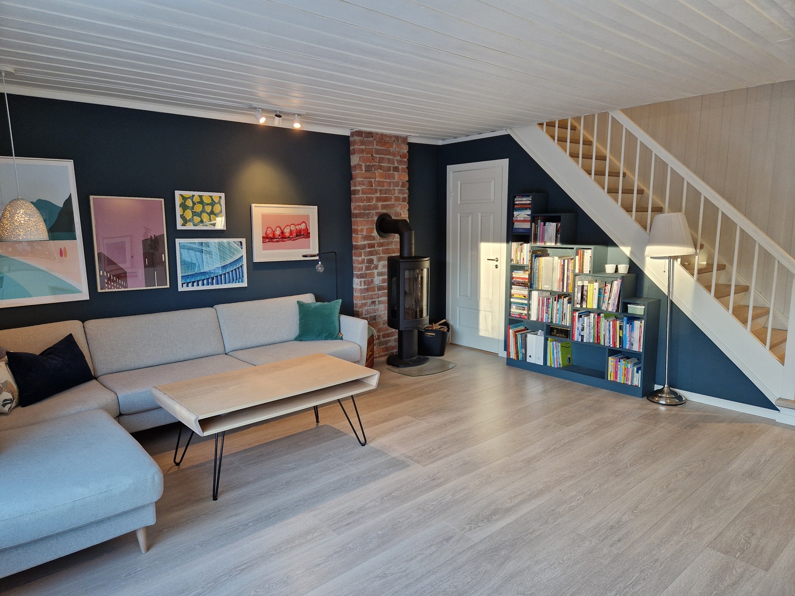 Stue med dør ned til kjeller og åpen trappeløsning opp til 2.etasje. Galleribilde