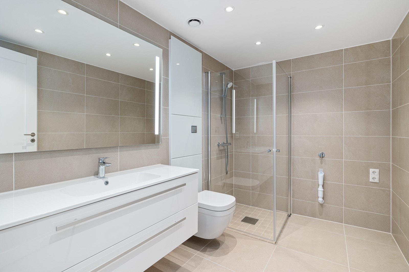 Eksklusive bad med vannbåren gulvvarme 60*60 fliser på gulv. Grohe vegghengt toalett samt Grohe blandebatterier. 120 innredning med nedfelt servant. Downlights i tak. Galleribilde