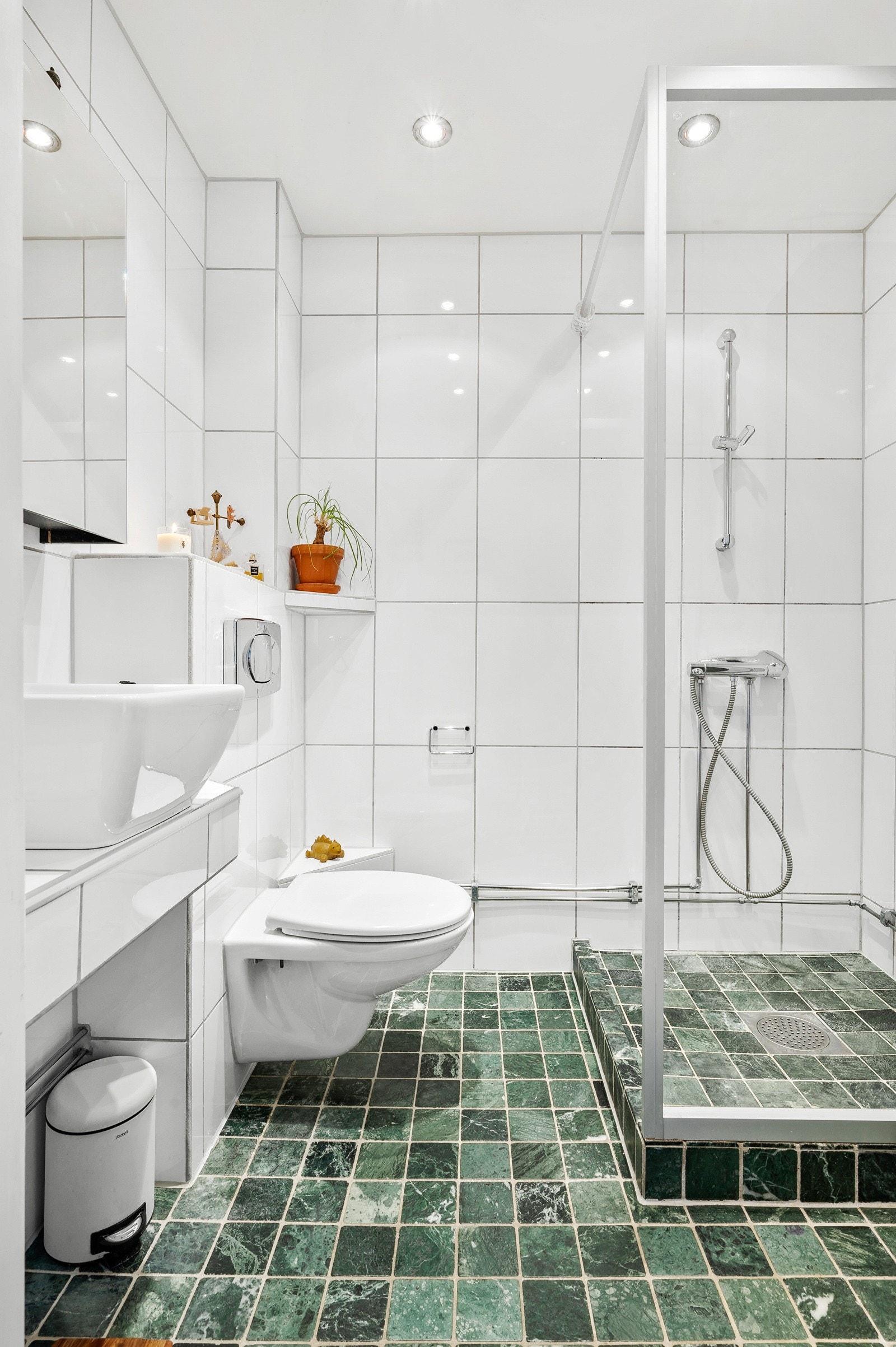 Badet har flislagte gulv og vegger, gulvvarme og nedsenket himling med downlights. Galleribilde