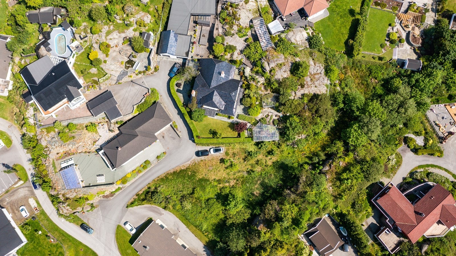 Tomten er lettstelt og nydelig opparbeidet med asfaltert gårdsplass, store områder med singel, flere store terrasser (den ene er overbygd), flotte bedd samt store og lekre (kostbare) natursteinsmurer Galleribilde
