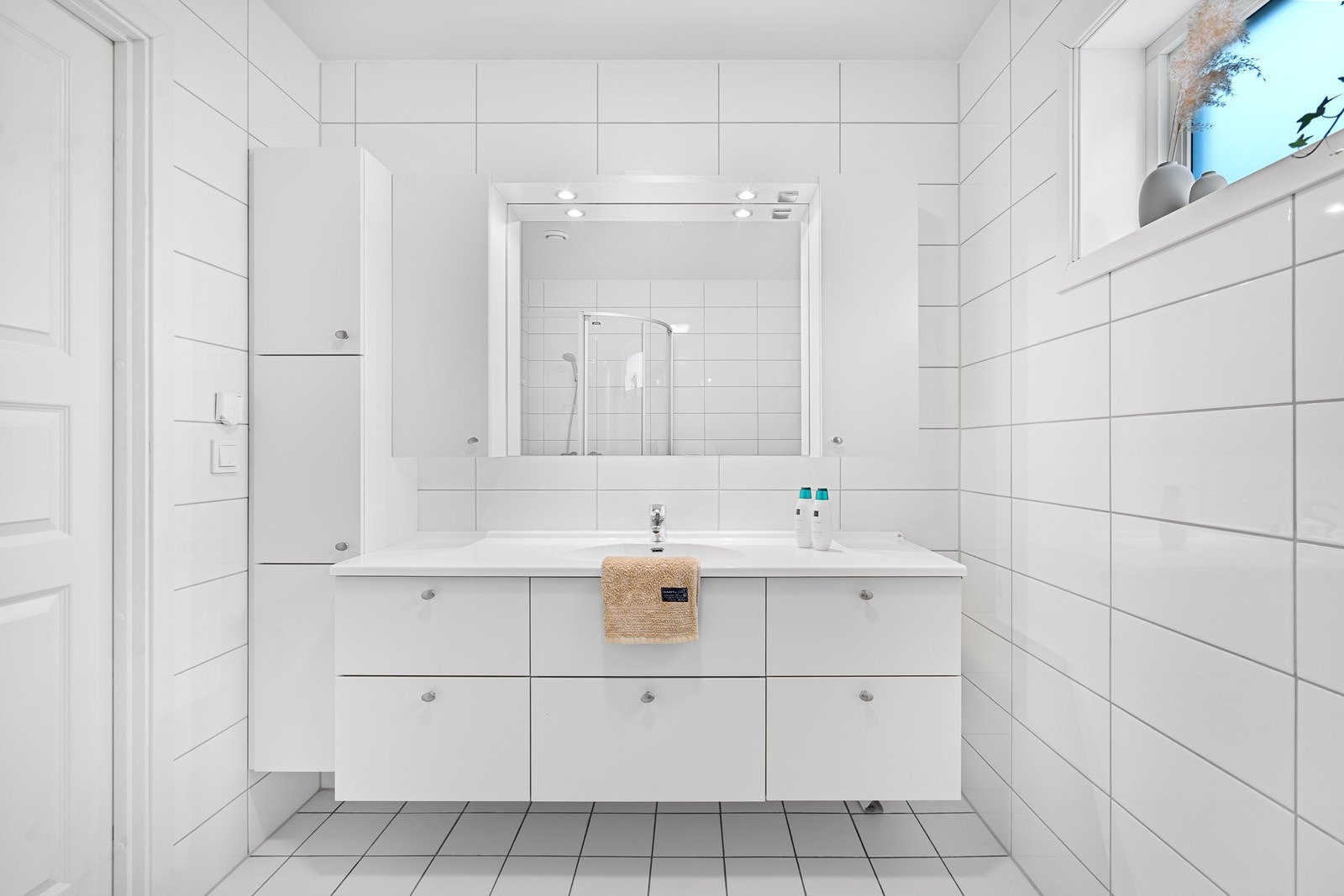 Badet er delikat med hvite fliser på gulv og vegger. Galleribilde