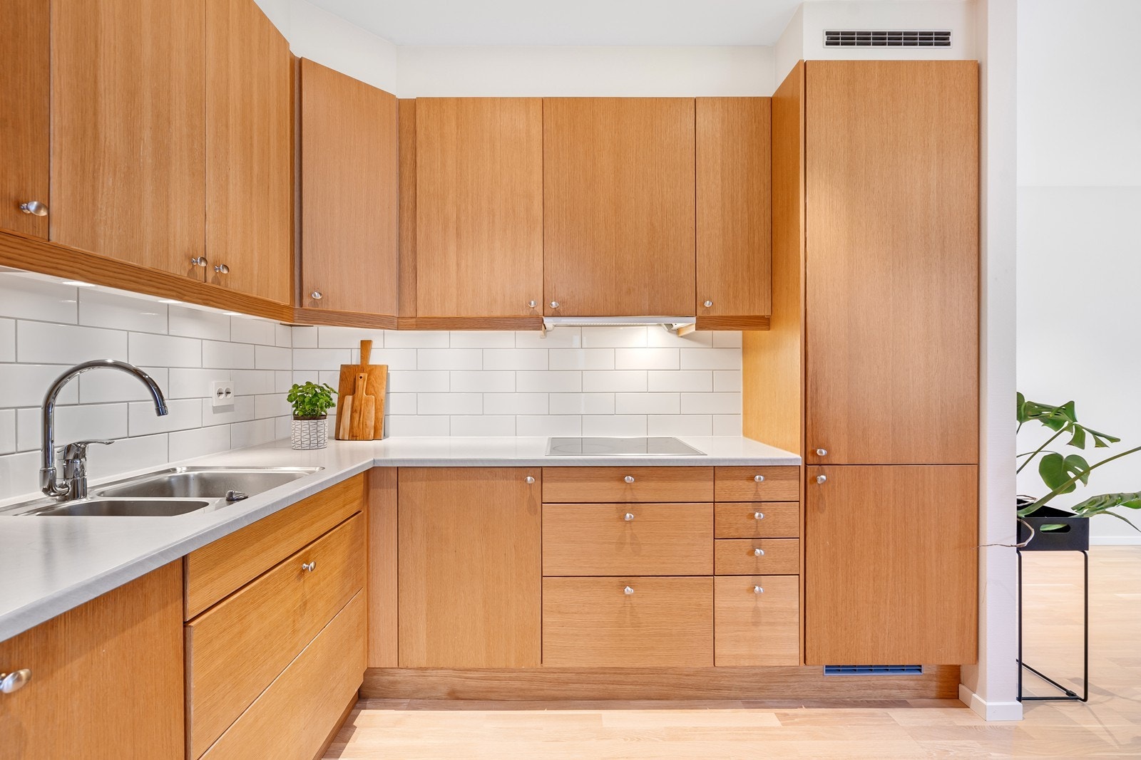 Fine detljer som lys under overskapene og fliser over kjøkkenbenken. Galleribilde