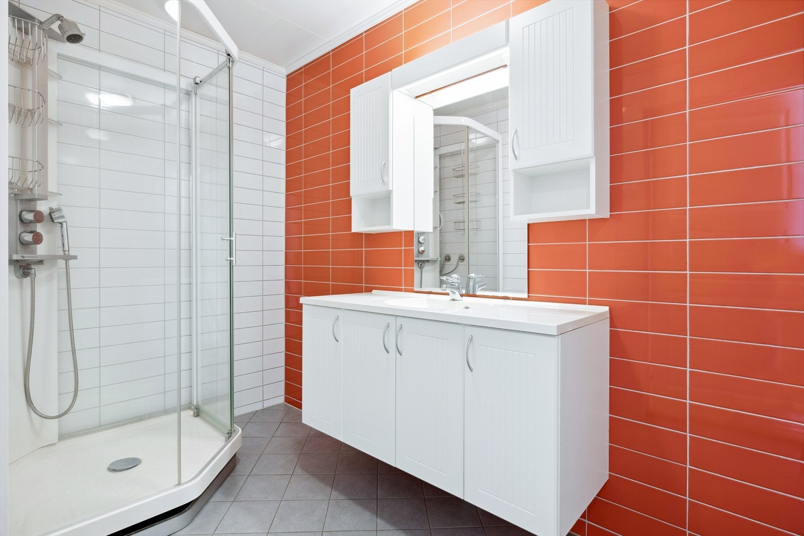 Badet er innredet med baderomsinnredning med servant, overskap, speil med belysning og dusjkabinett, samt opplegg for vaskemaskin. Galleribilde