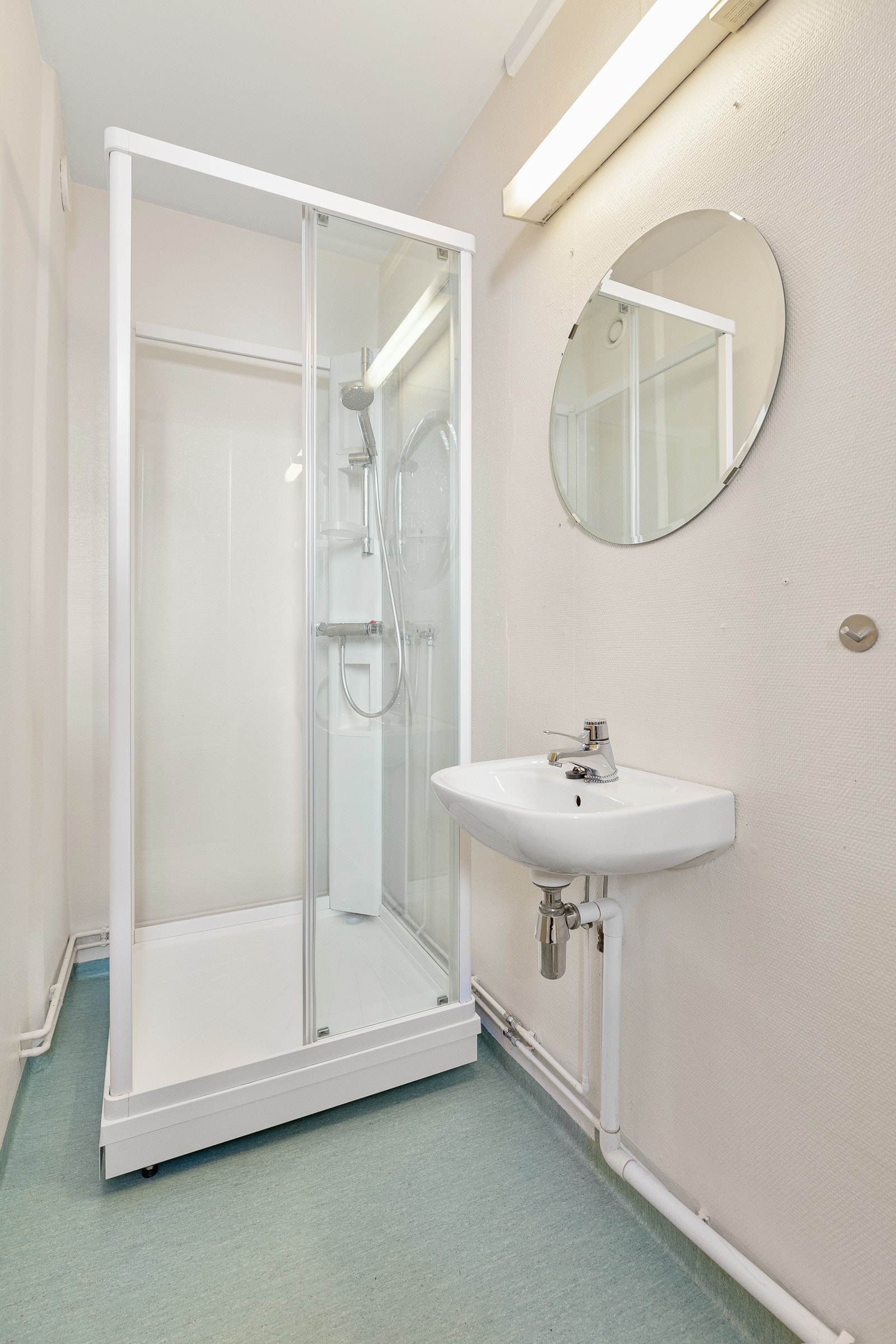 Romslig bad med belegg på gulv og strietapet på vegger. Galleribilde