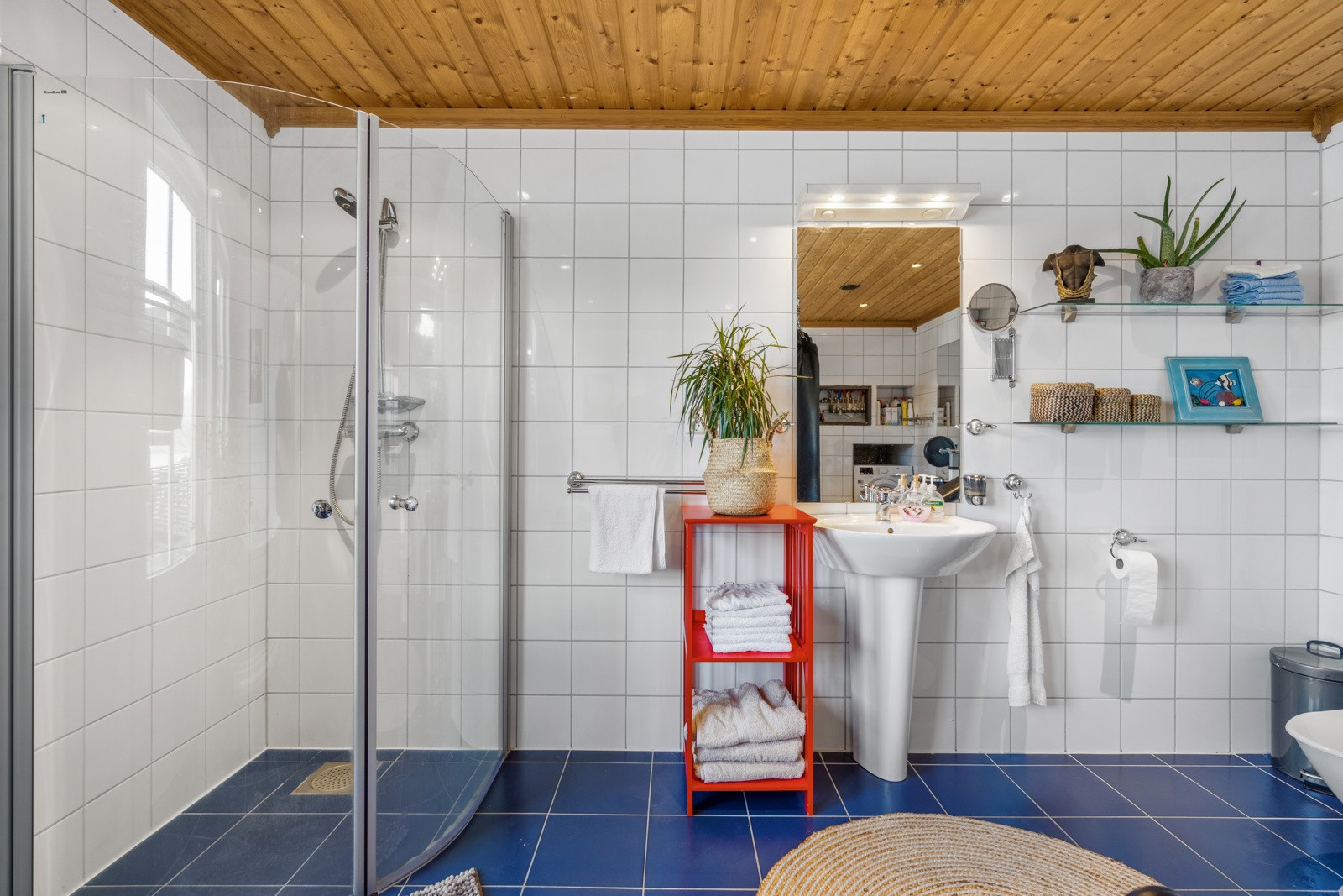 Innredet med badekar, et praktisk og plassbesparende dusjhjørne,servant og toalett.