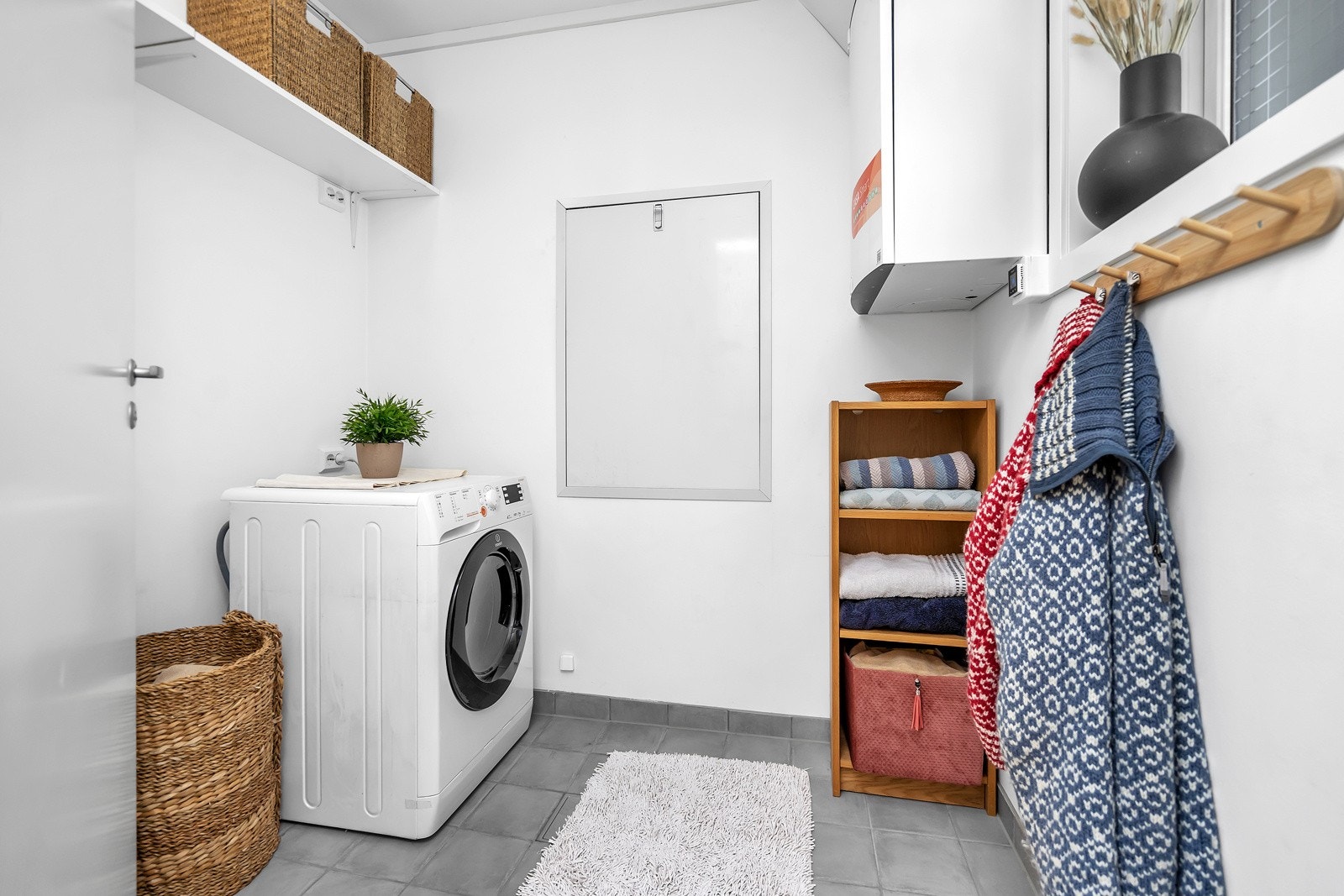 Vaskerom med opplegg for vaskemaskin og god plass for oppbevaring Galleribilde
